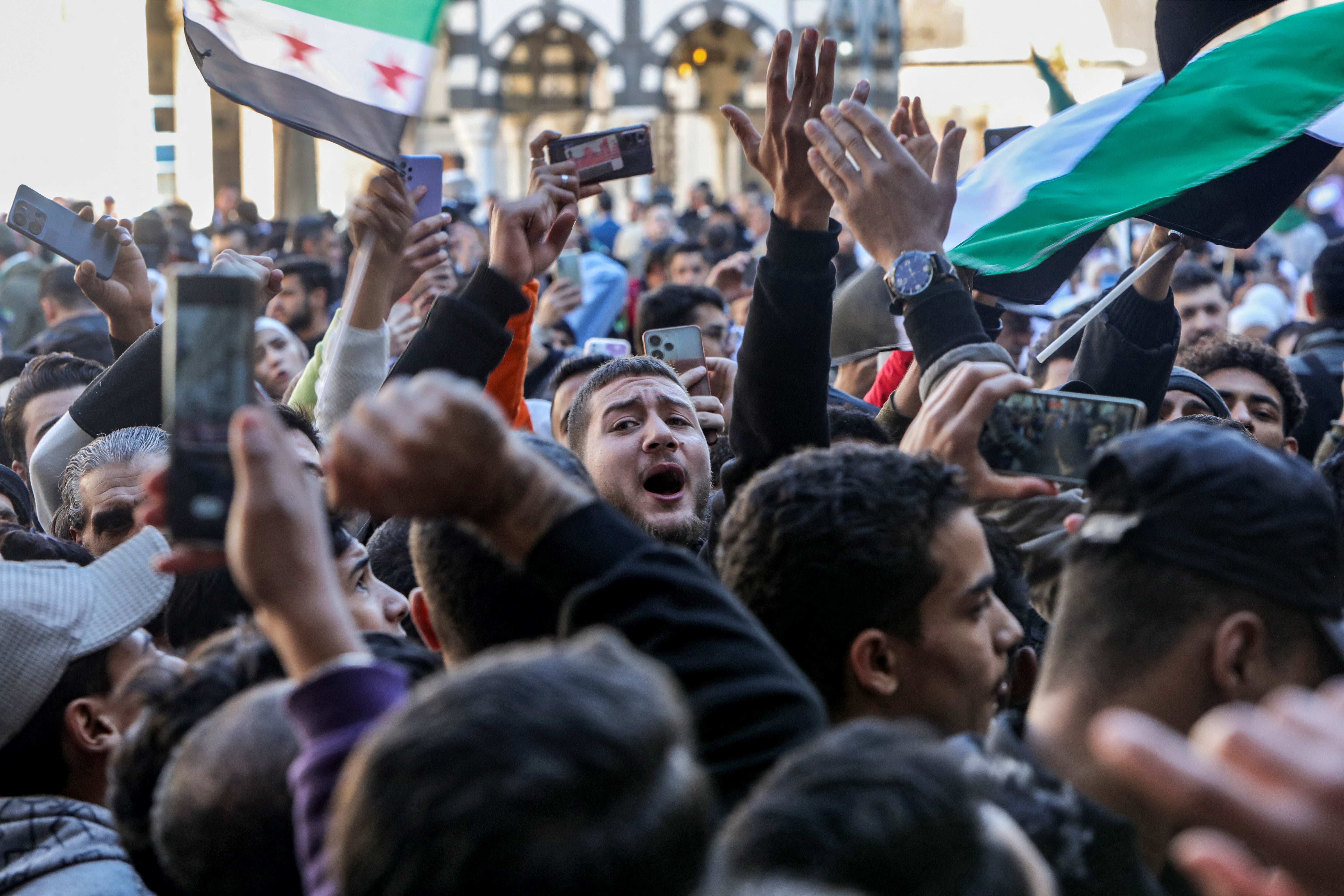 Syrians celebrate in the courtyard of the Umayyad mosque in the old city of Damascus