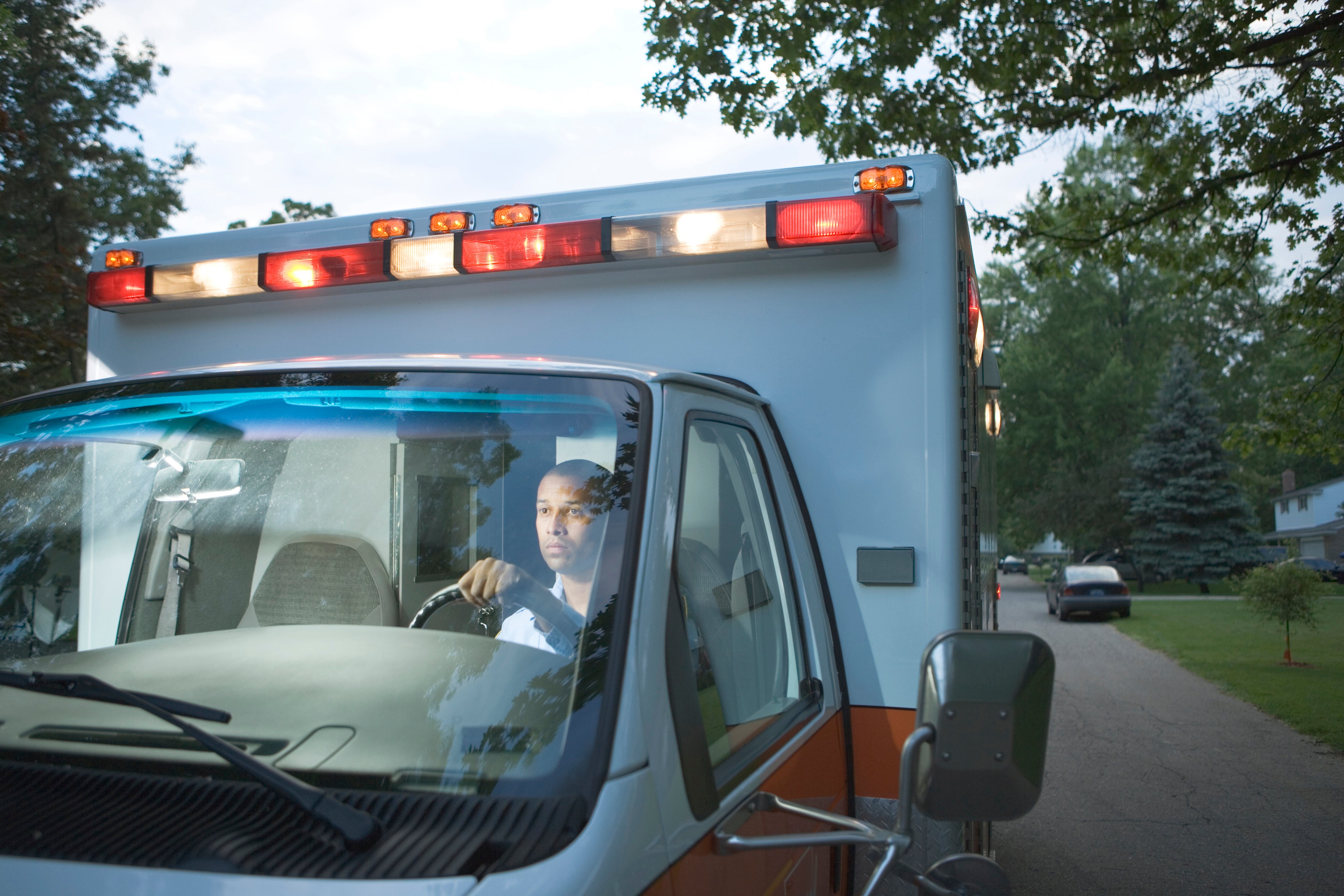 A male ambulance driver is seen driving through a residential area. A new study found ambulance and taxi drivers had the lowest proportion of deaths from Alzheimer’s disease compared to hundreds of other occupations