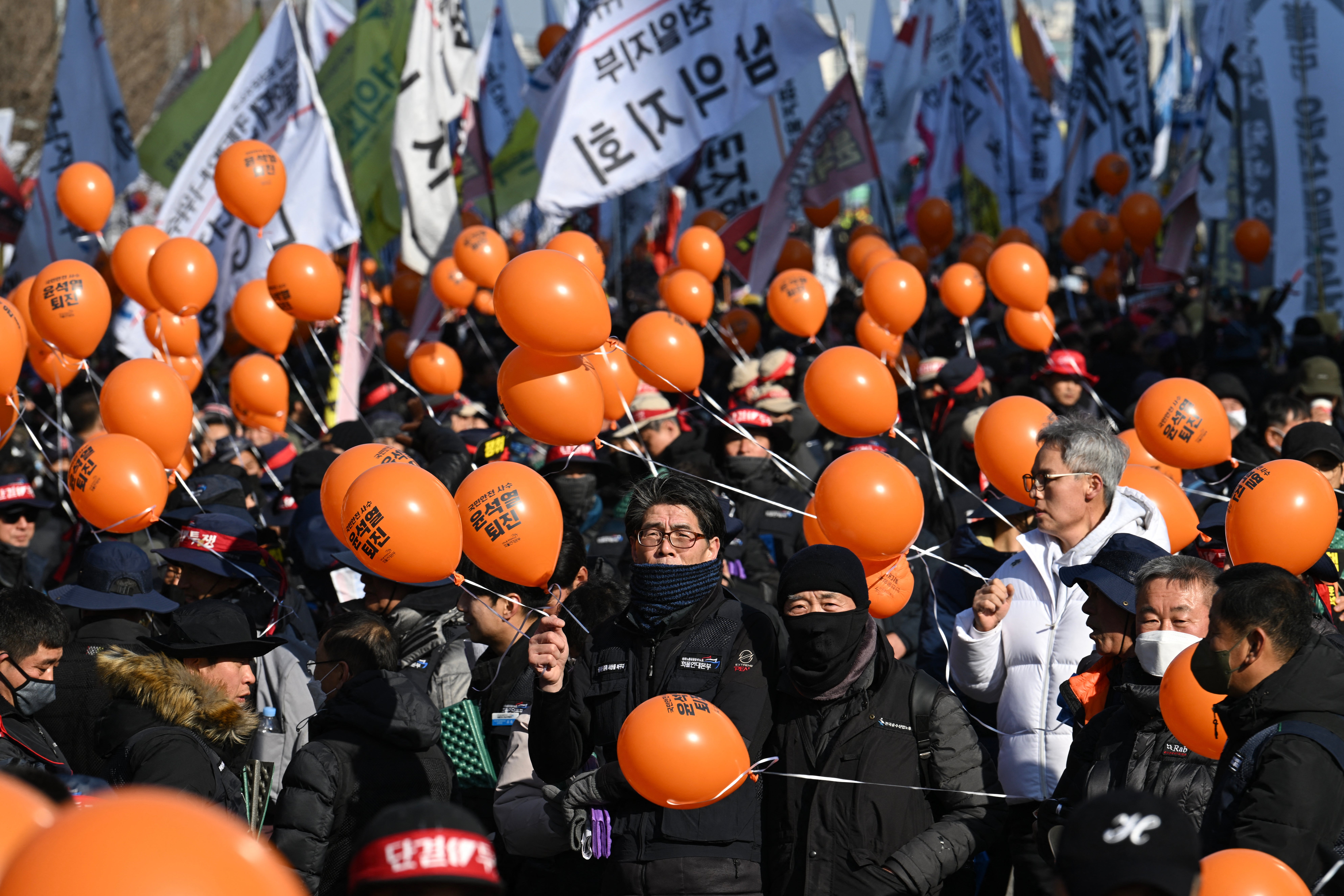 People holding balloons reading ‘Step down Yoon Suk Yeol’ as they take part in a protest calling for his ouster