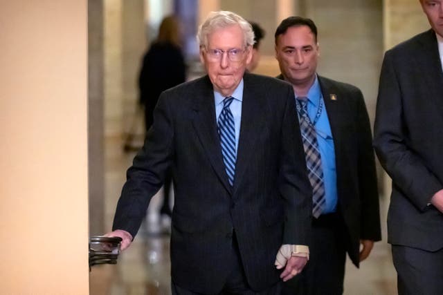 <p>Senate Minority Leader Mitch McConnell of Ky., left, wears a bandage on his face and wrist as he walks to cast a vote last week.  </p>