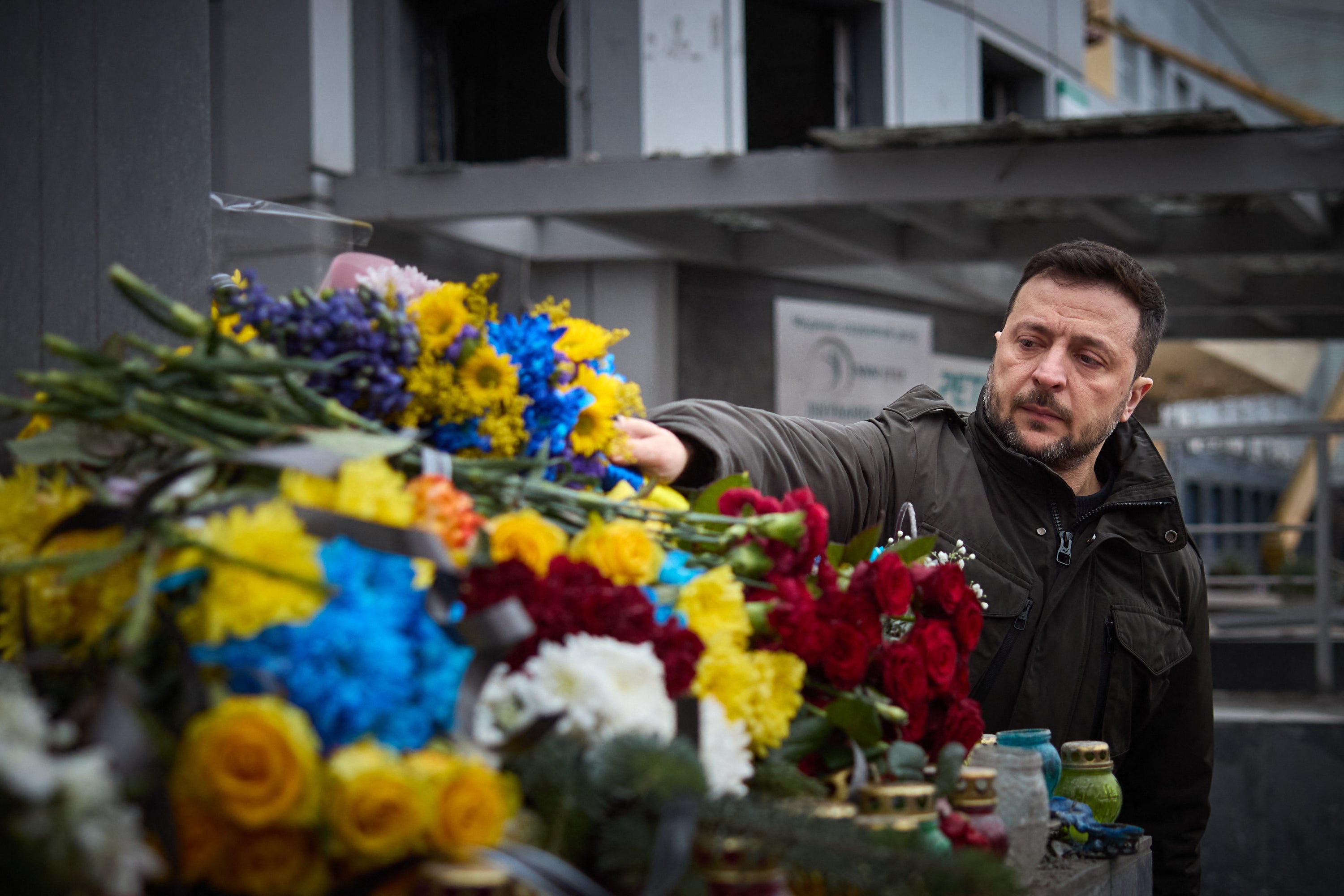 Ukrainian president Volodymyr Zelensky lays flowers at the site of the missile strike carried out by Russia on 10 December in the city of Zaporizhzhia