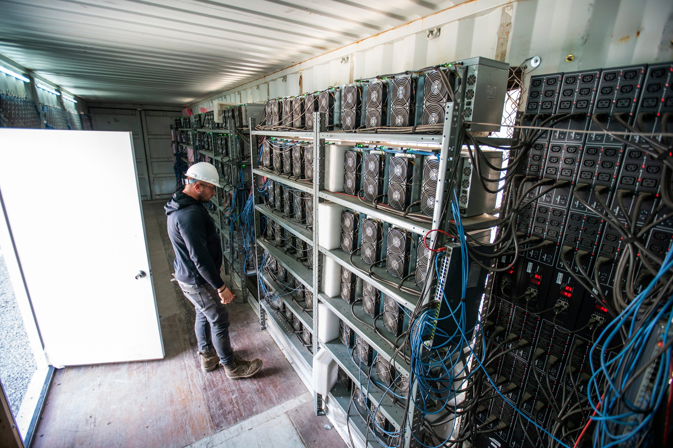 Chris Radwanski, data center supervisor, checks on Bitcoin mining machines in a shipping container behind the Scrubgrass Power plant in Russellton, Pennsylvania in 2021. Cooling the equipment stored in data farms can require up to 5 million gallons of water per day
