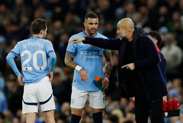<p>Pep Guardiola gives instructions to Kyle Walker and Bernardo Silva</p>