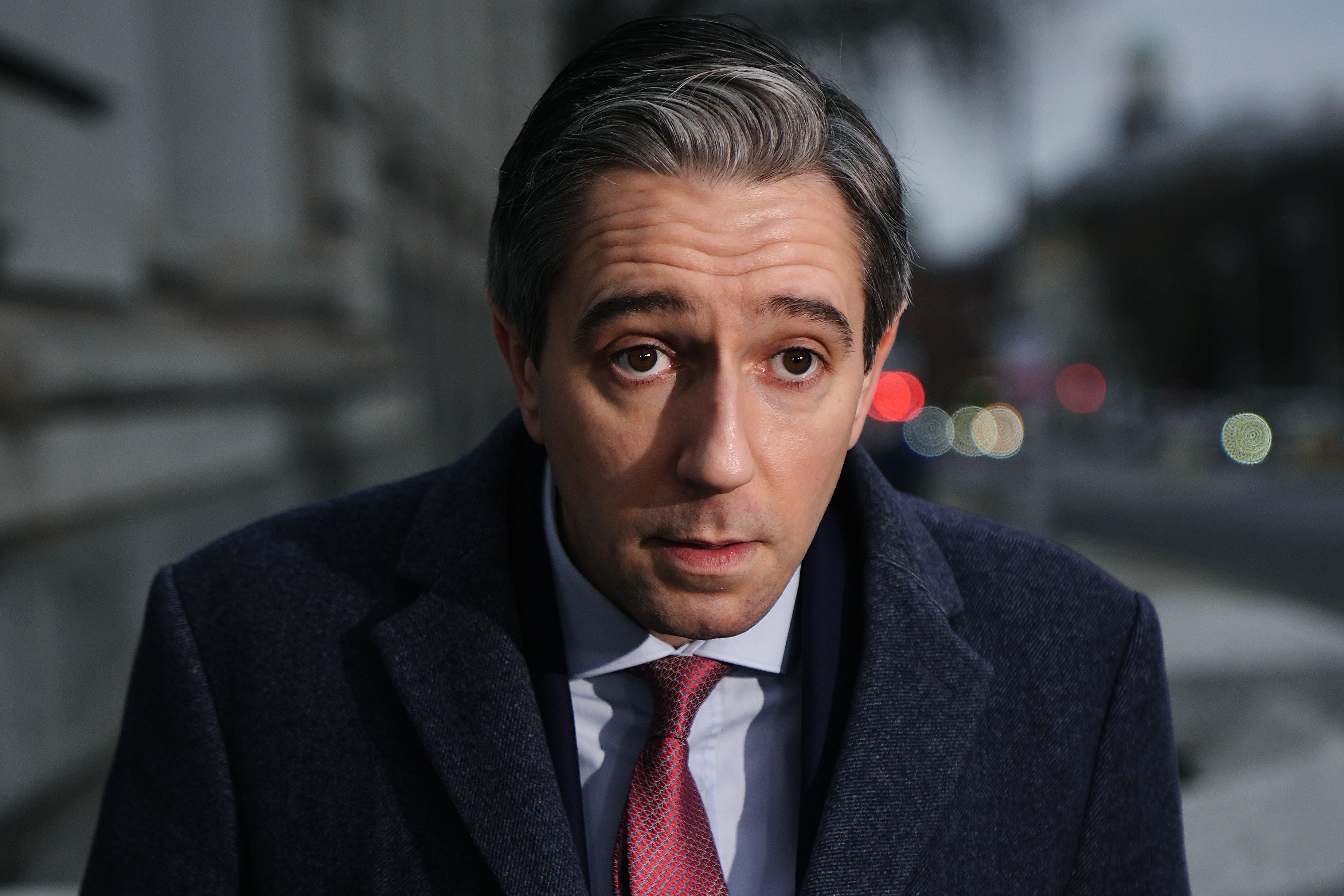 Taoiseach Simon Harris speaking to members of the media outside Government Buildings (PA)