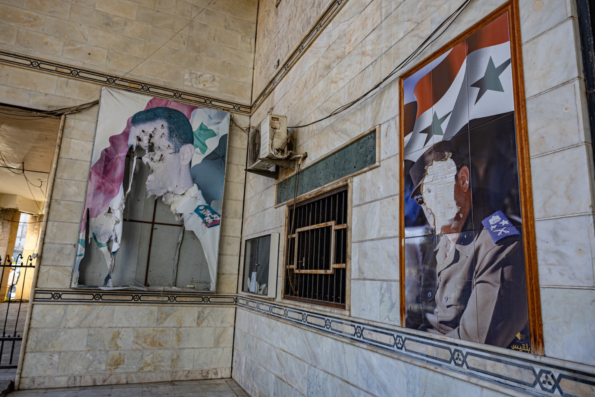 Defaced images of Bashar al-Assad inside the police headquarters in Homs