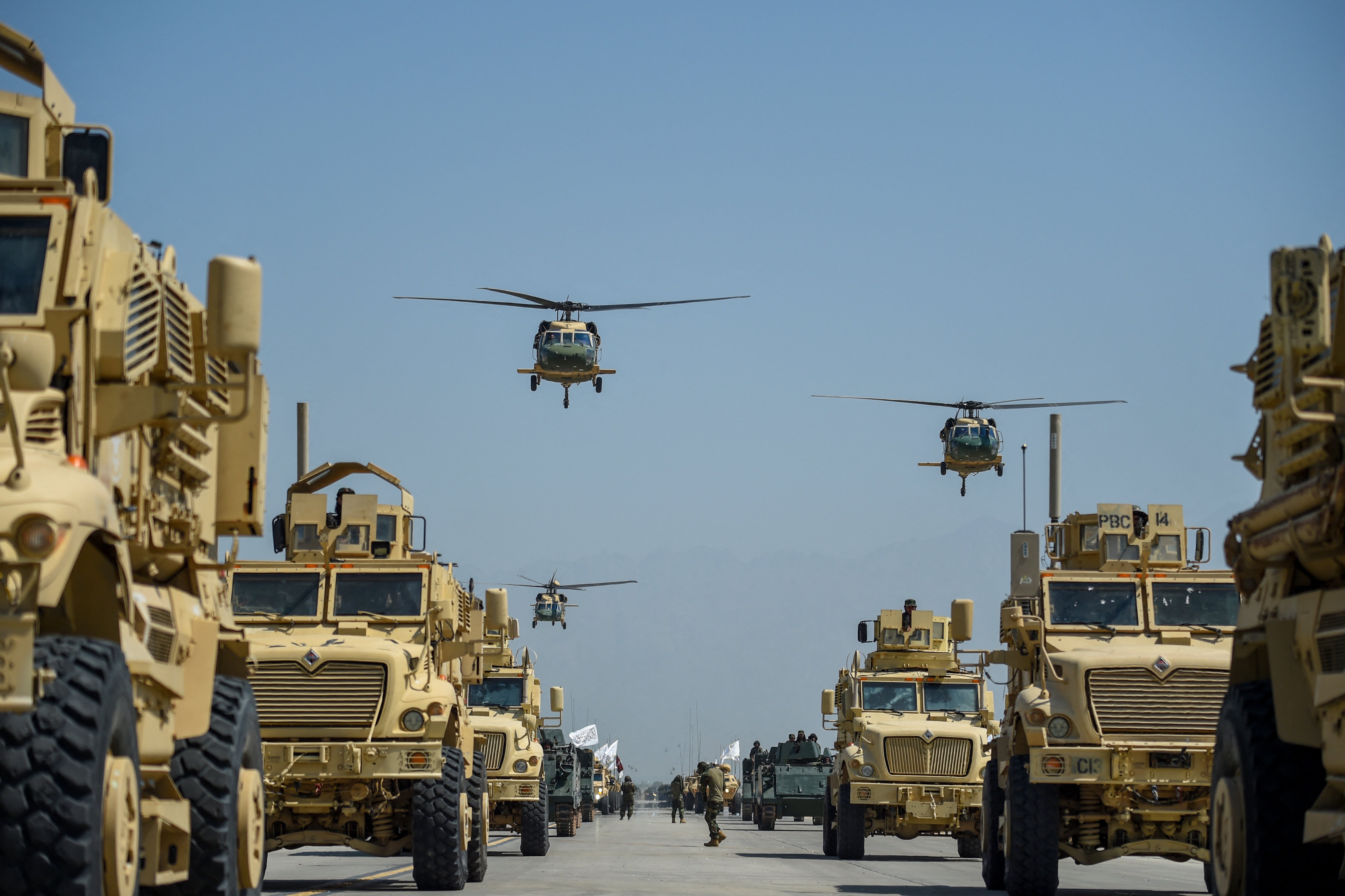 Taliban military helicopters fly to celebrate the third anniversary of Taliban’s takeover of Afghanistan, at the Bagram Air Base