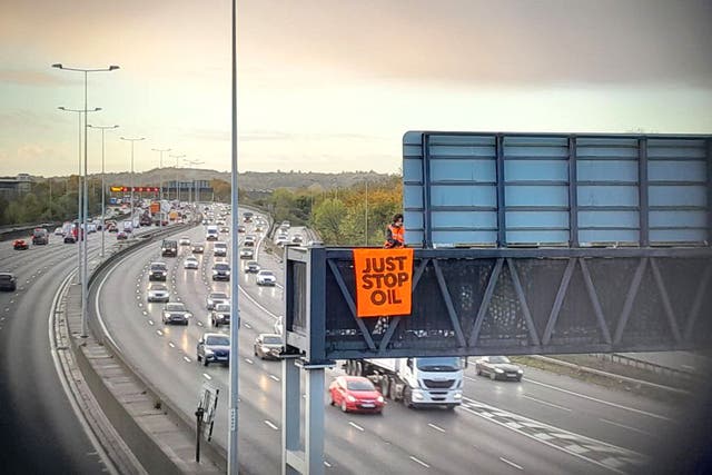 Protesters on a gantry over the M25 in November 2022 (Just Stop Oil/PA)