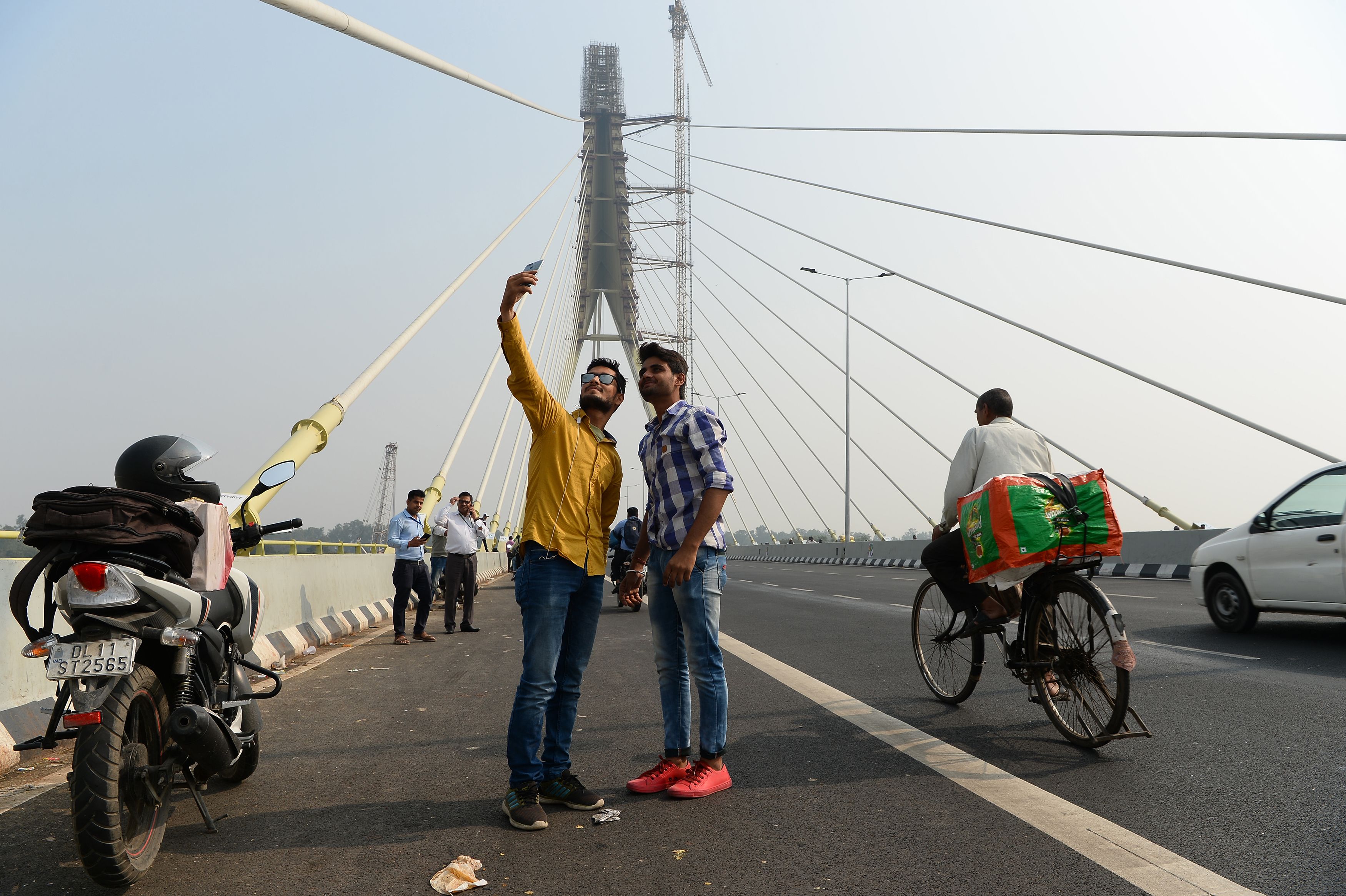 Indian youths take a selfie photograph on the newly-built Signature Bridge in New Delhi in 2018