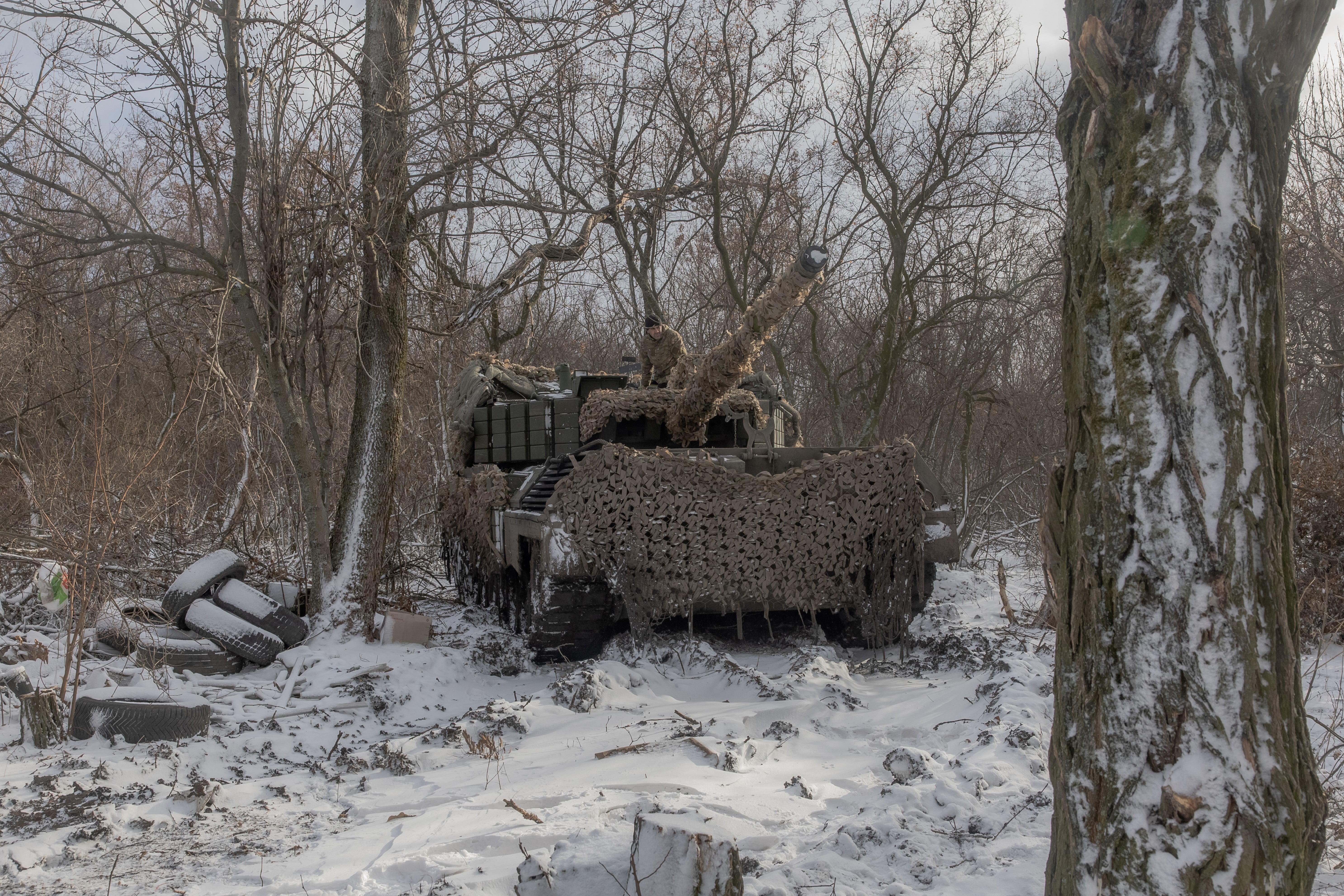 A Ukrainian tank crew member stands on a Leopard 1A5 tank at a frontline position near Pokrovsk