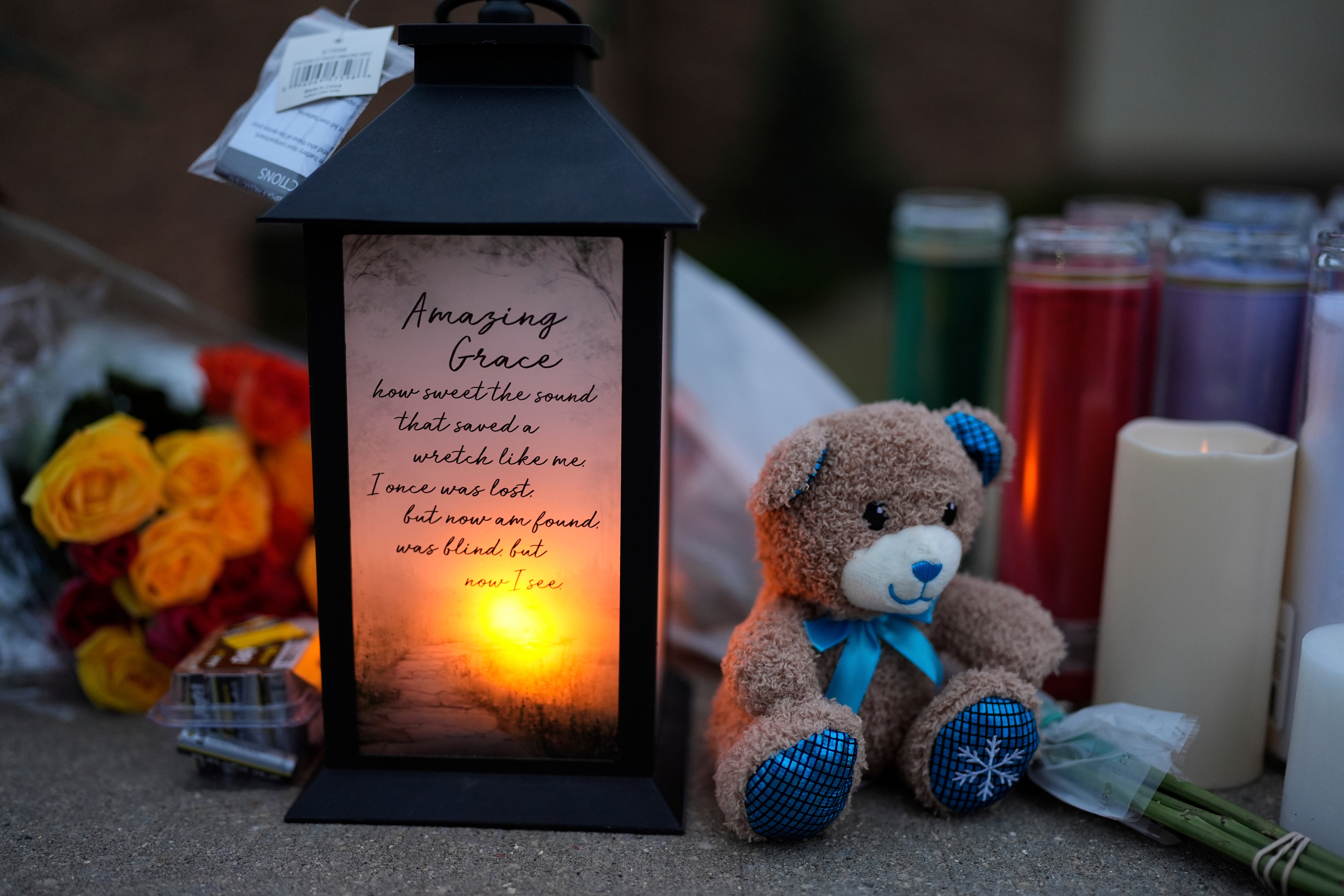 Flowers and candles are placed outside the Abundant Life Christian School Tuesday, Dec. 17, 2024 in Madison, Wis., following a shooting on Monday