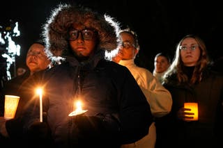 Para pendukung memegang lilin saat menyalakan lilin pada hari Selasa di luar Wisconsin Capitol di Madison