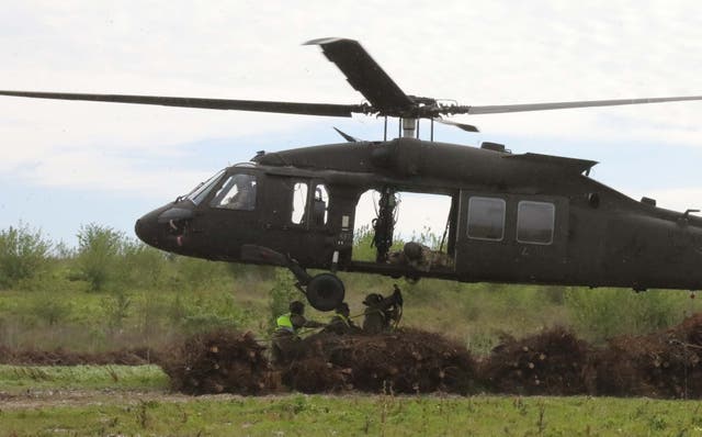 <p>Christmas trees are dropped out of a Louisiana National Guard helicopter at the Bayou Sauvage National Wildlife Refuge. Thousands of the trees are included in the project </p>