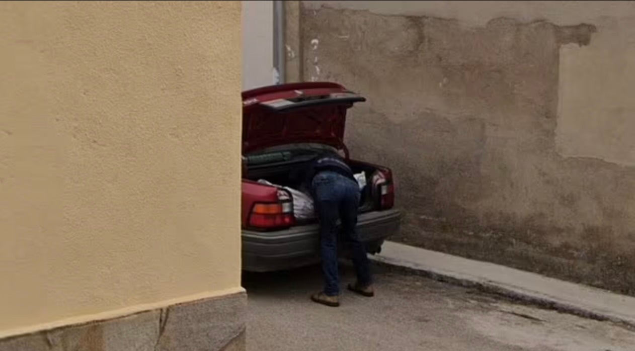 One man is seen bending over a body-shaped package in the car boot in the image captured for Google Maps