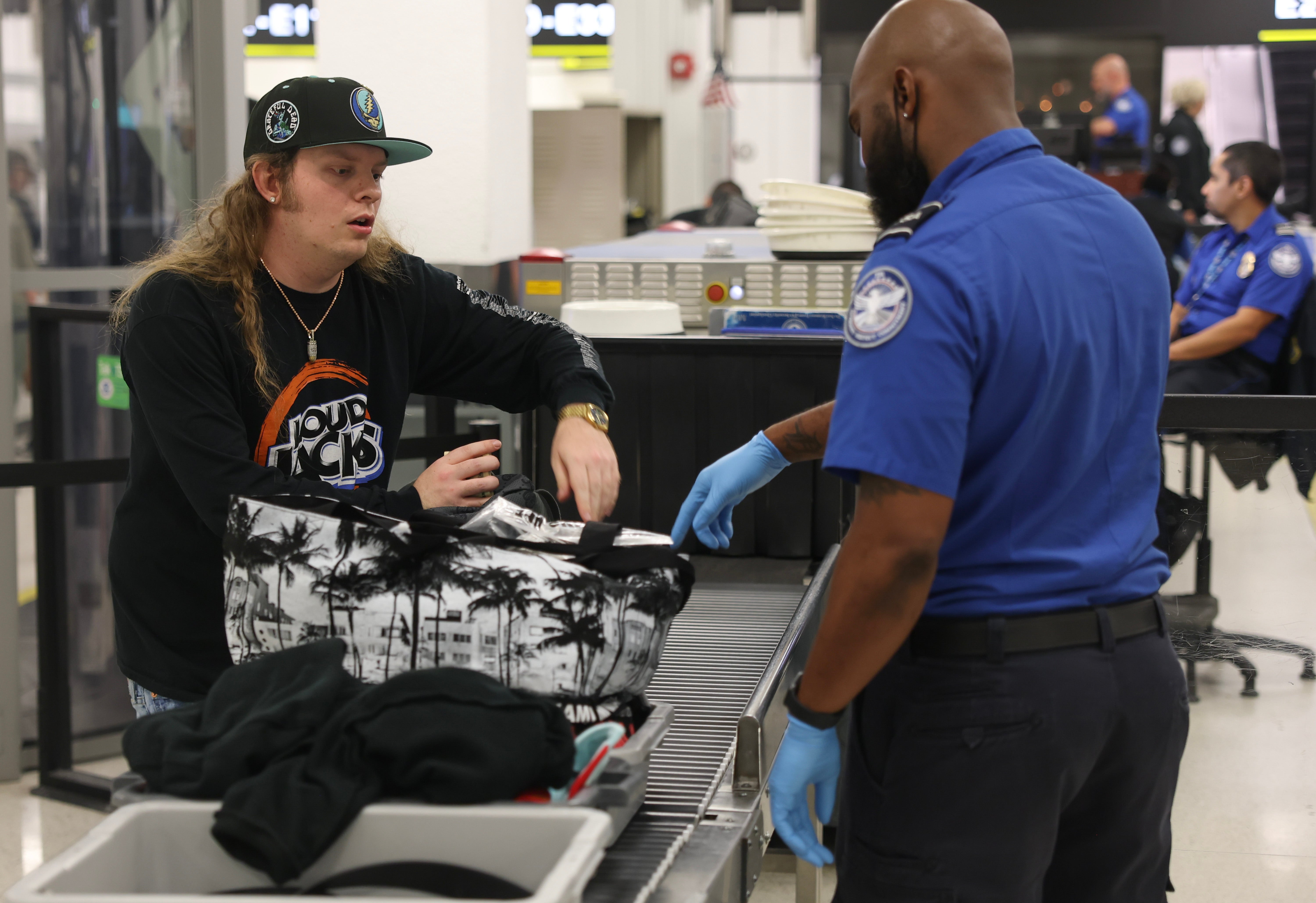 A passenger passes through the TSA checkpoint at Florida’s Miami International Airport on Tuesday. South Florida may see some flooding on Wednesday