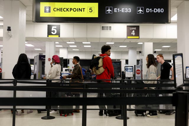 <p>Passengers pass through the TSA checkpoint at Florida’s Miami International Airport on Tuesday. Nearly 120 million Americans are expected to travel for the holidays this month </p>