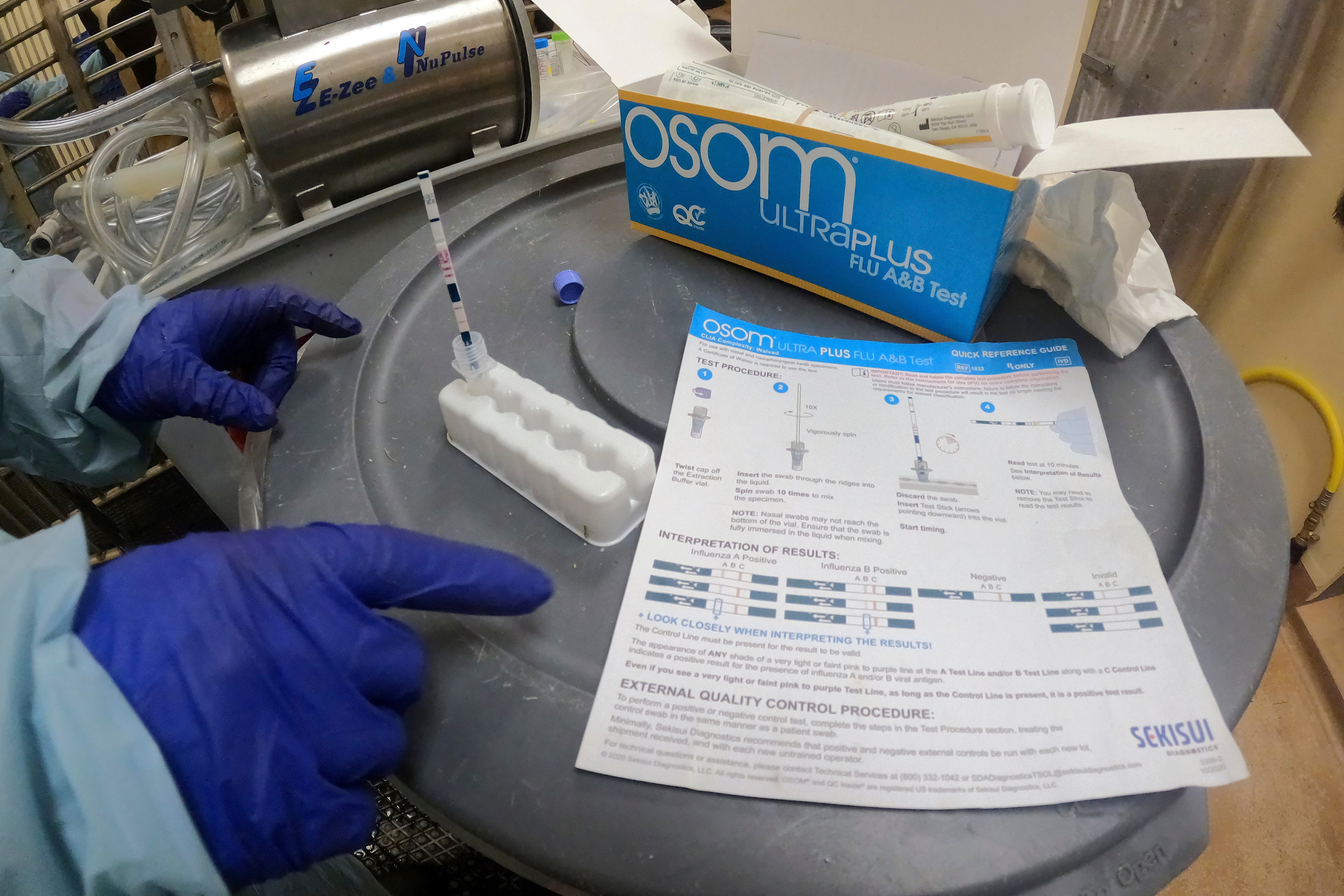 A researcher performs a rapid antigen test on milk from a dairy cow inoculated against bird flu in an Iowa research facility last July. Agriculture officials have ordered national milk testing