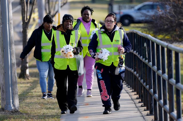 <p>A group walks to a site to leave flowers outside the Abundant Life Christian School, scene of a deadly shooting Monday. </p>