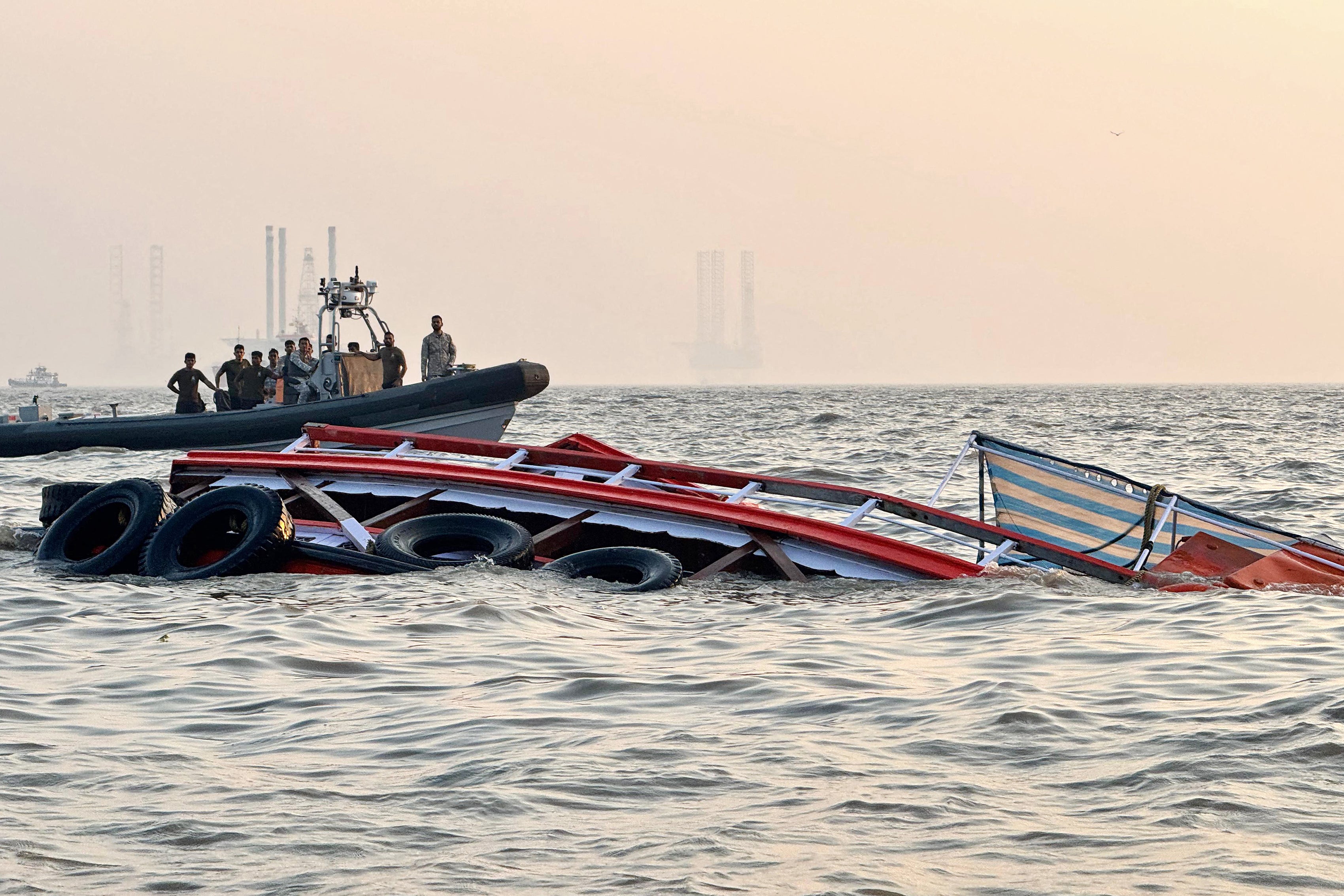 Indian defence personnel carrying out a rescue operation after an accident off the Mumbai coast