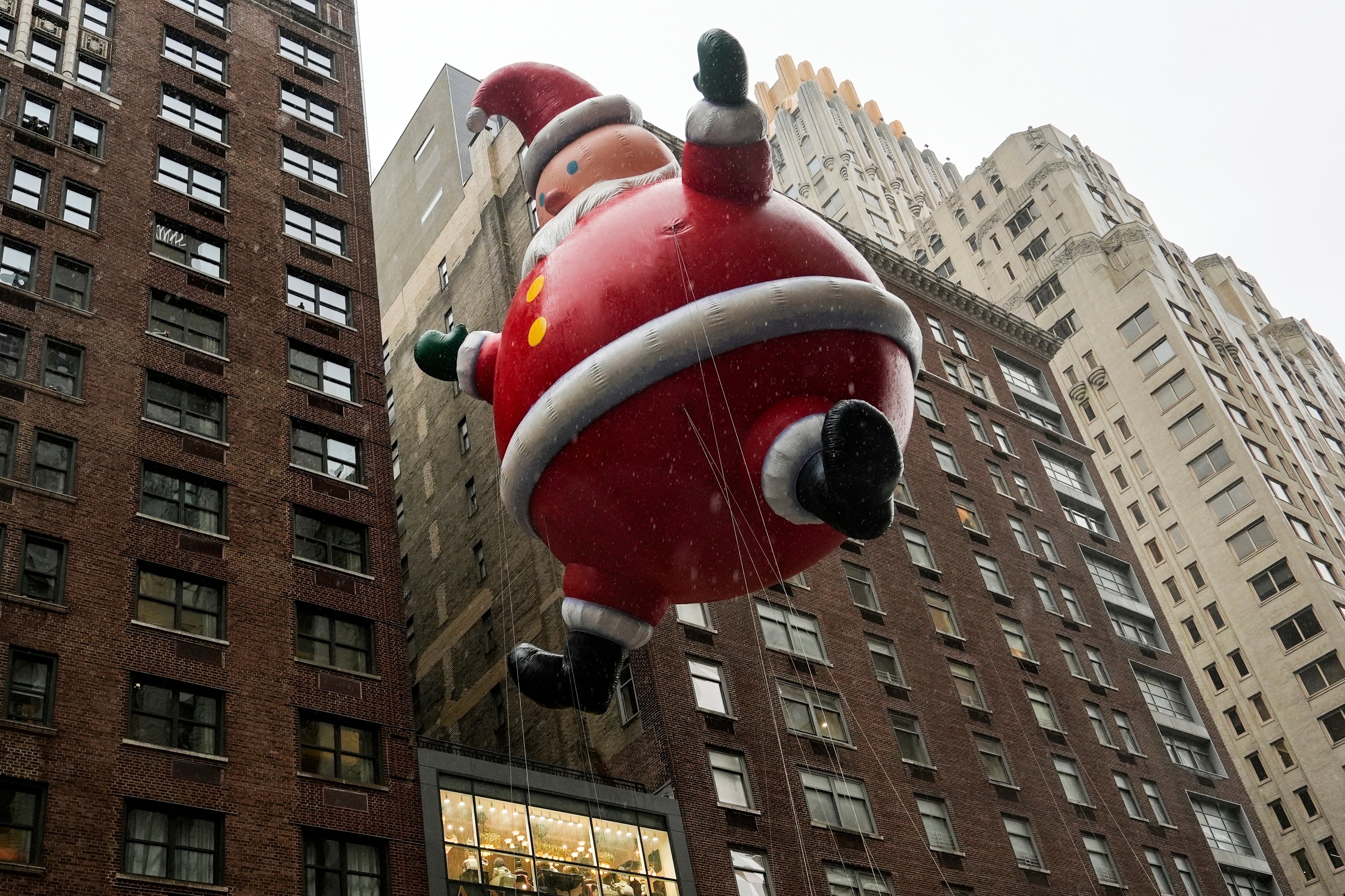 Handlers guide a Santa Claus balloon down Sixth Avenue during the Macy’s Thanksgiving Day Parade