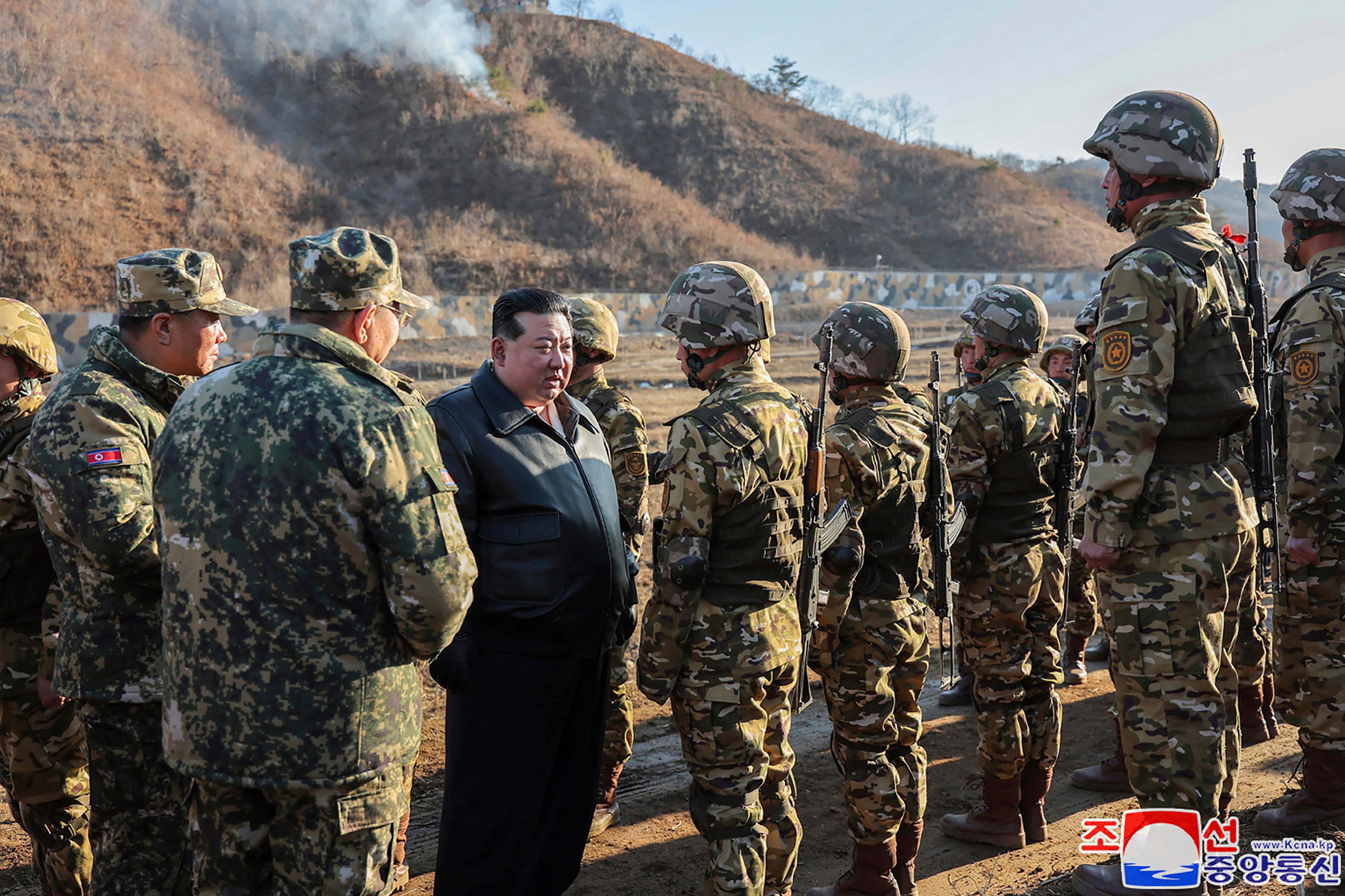 North Korean leader Kim Jong Un, center left, meets soldiers during a visit to a western operational training base in North Korea