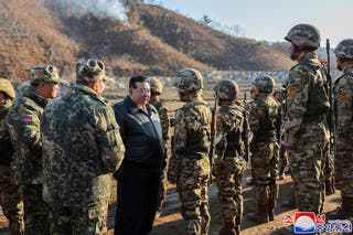 North Korean leader Kim Jong Un, center left, meets soldiers during a visit to a western operational training base in North Korea