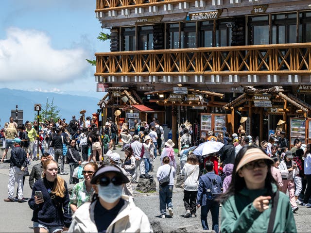 <p>Tourists are seen at Fuji Subaru Line 5th station, which leads to the popular Yoshida trail for hikers climbing Mount Fuji, in Yamanashi Prefecture on 19 June 2024</p>