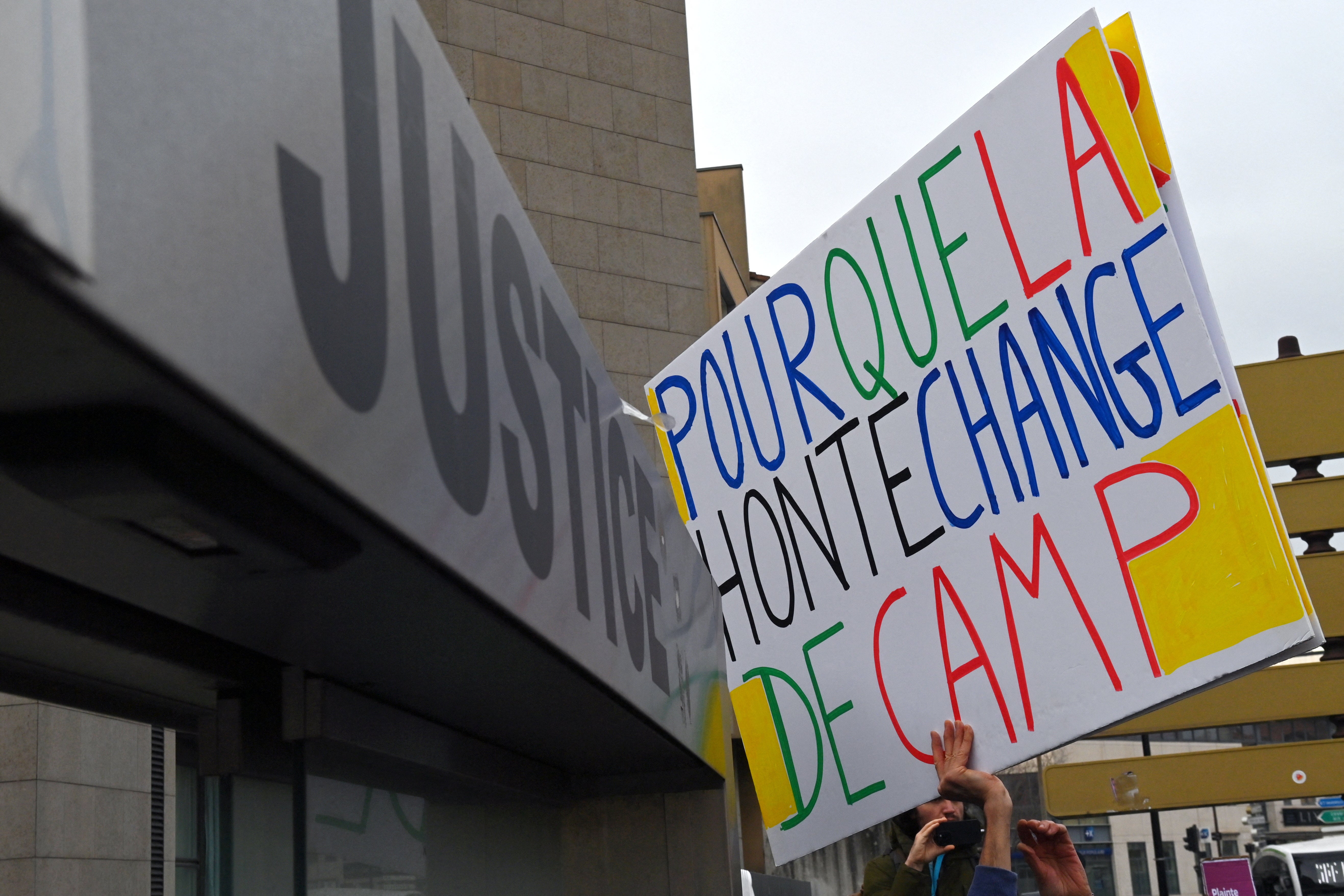 A man holds a placard which reads "So that shames changes sides"