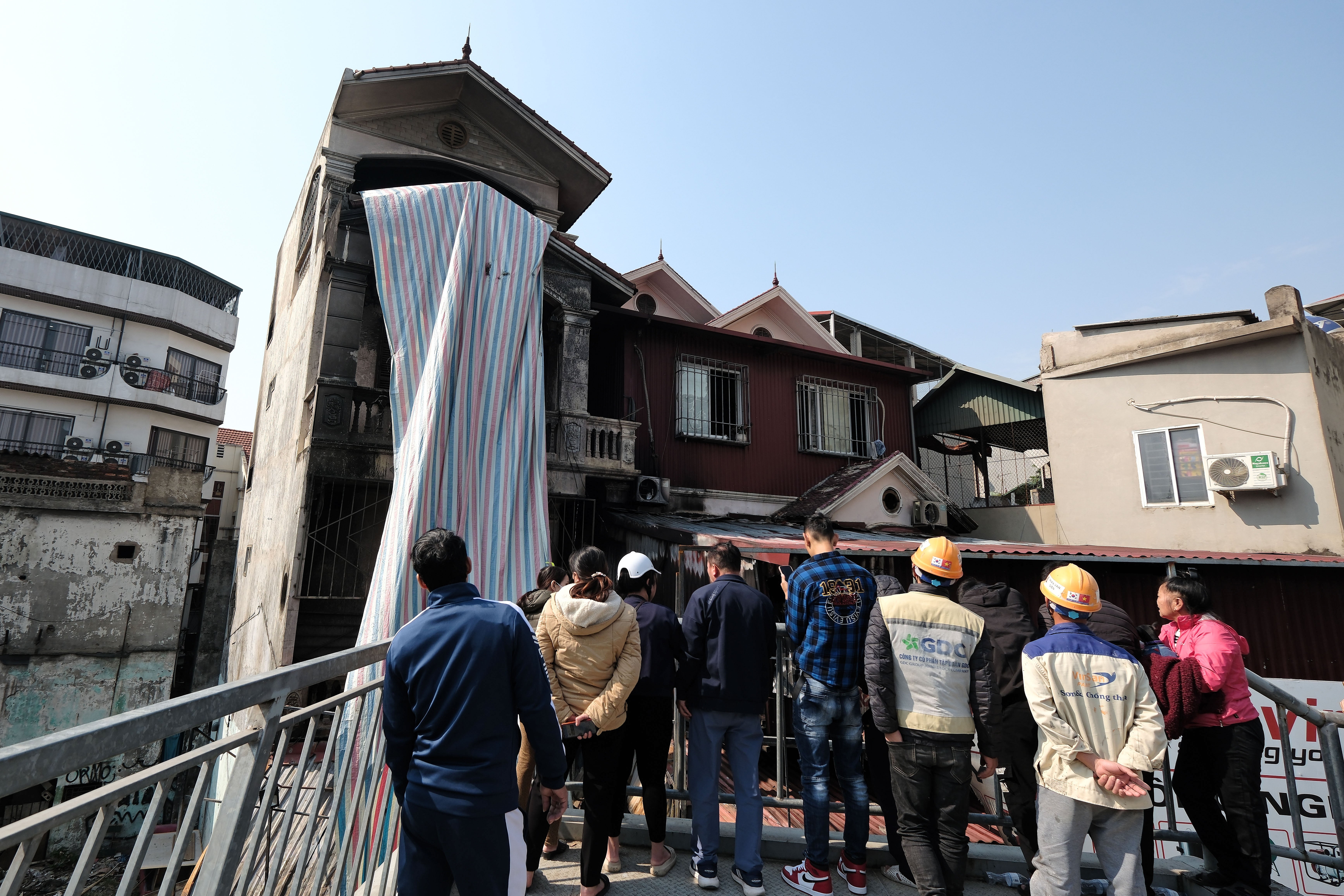 People gather near the site of a fire in Hanoi, Vietnam, 19 December 2024