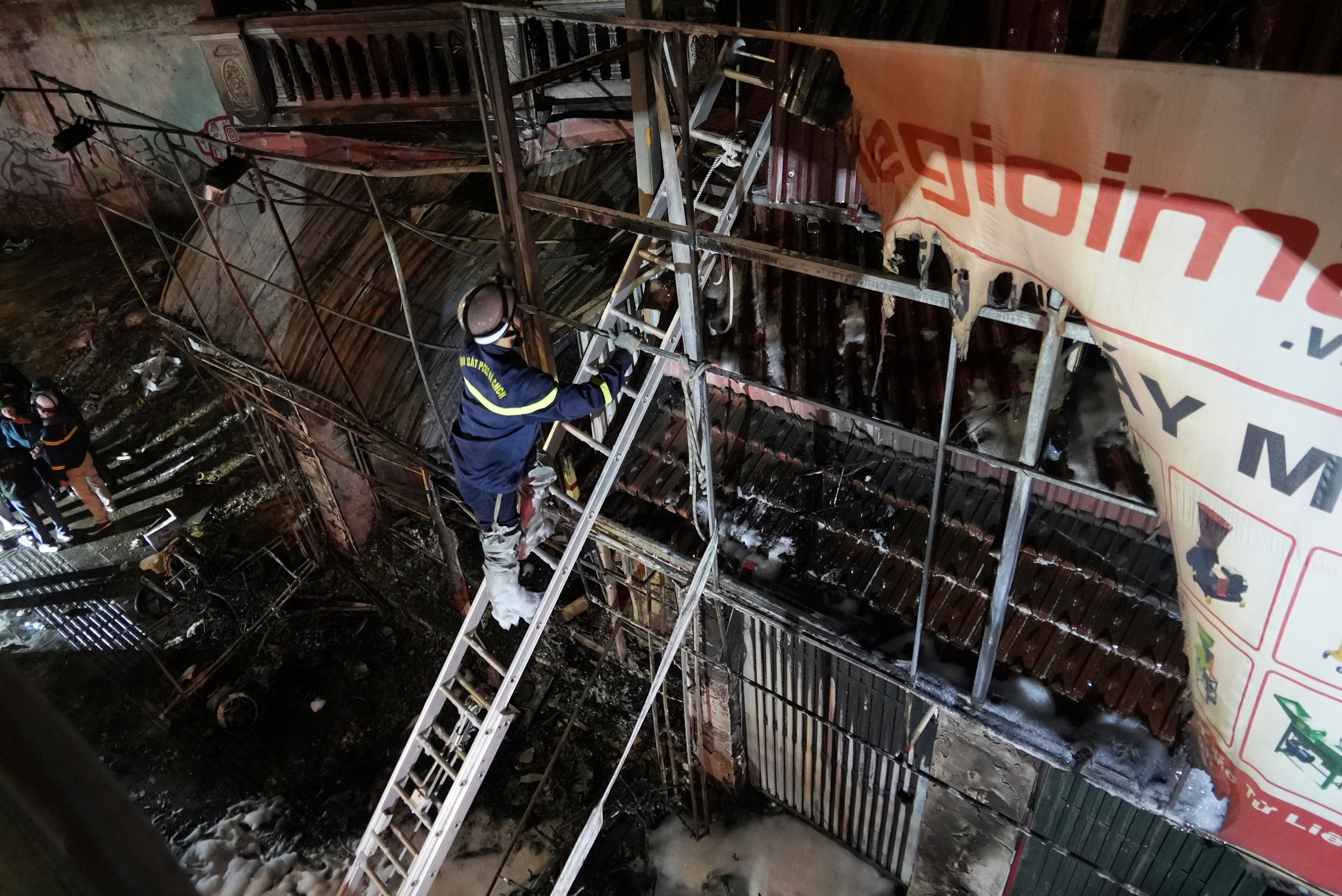 Fire personnel inspect a building burned down by a fire