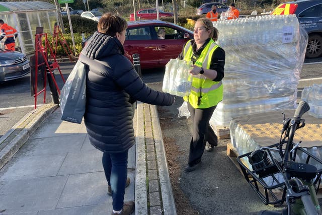 A resident collects water at a bottle station at Asda in Totton (Ben Mitchell/PA)