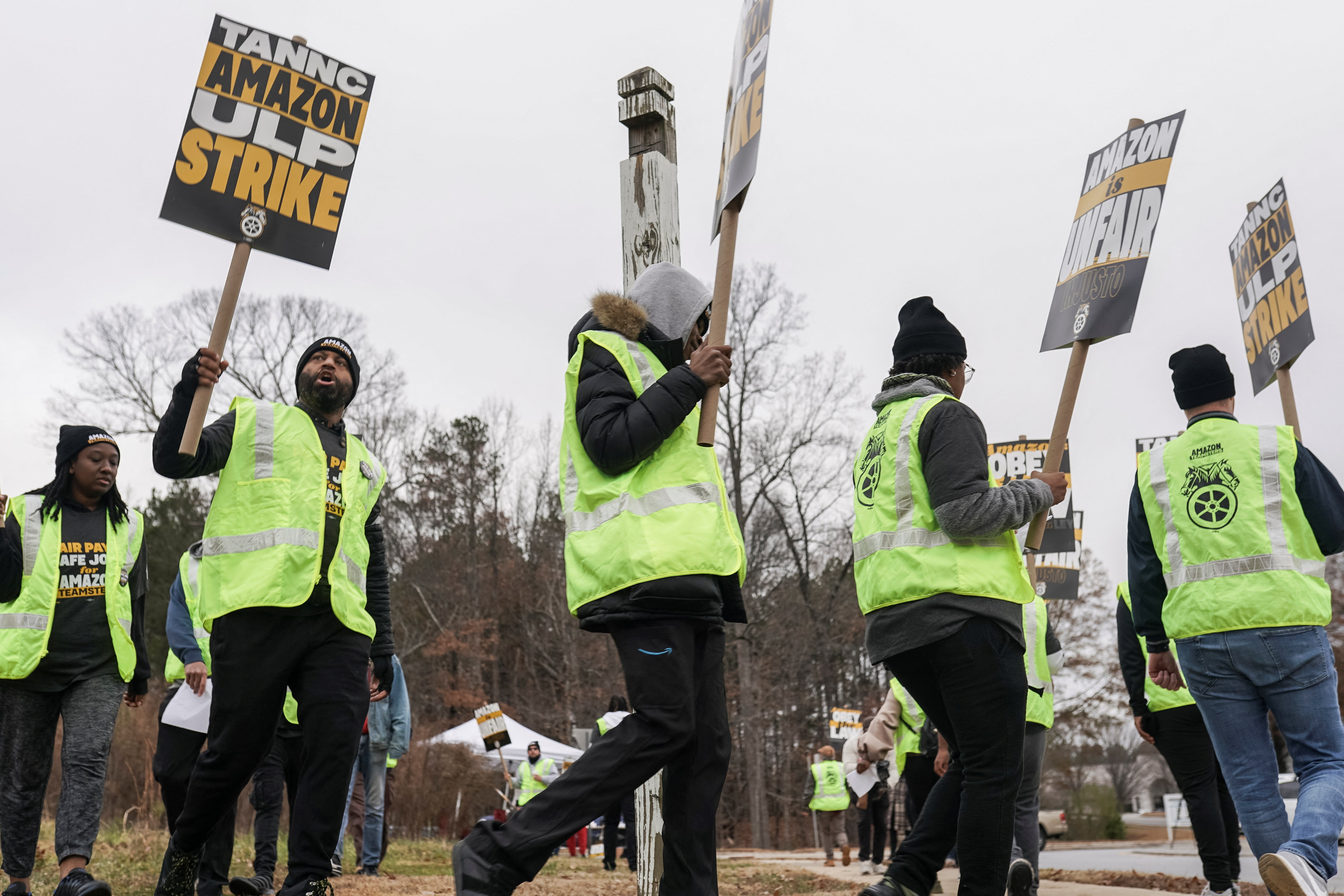 People hold signs and march during a strike by Teamsters union members at an Amazon facility in Alpharetta, Georgia