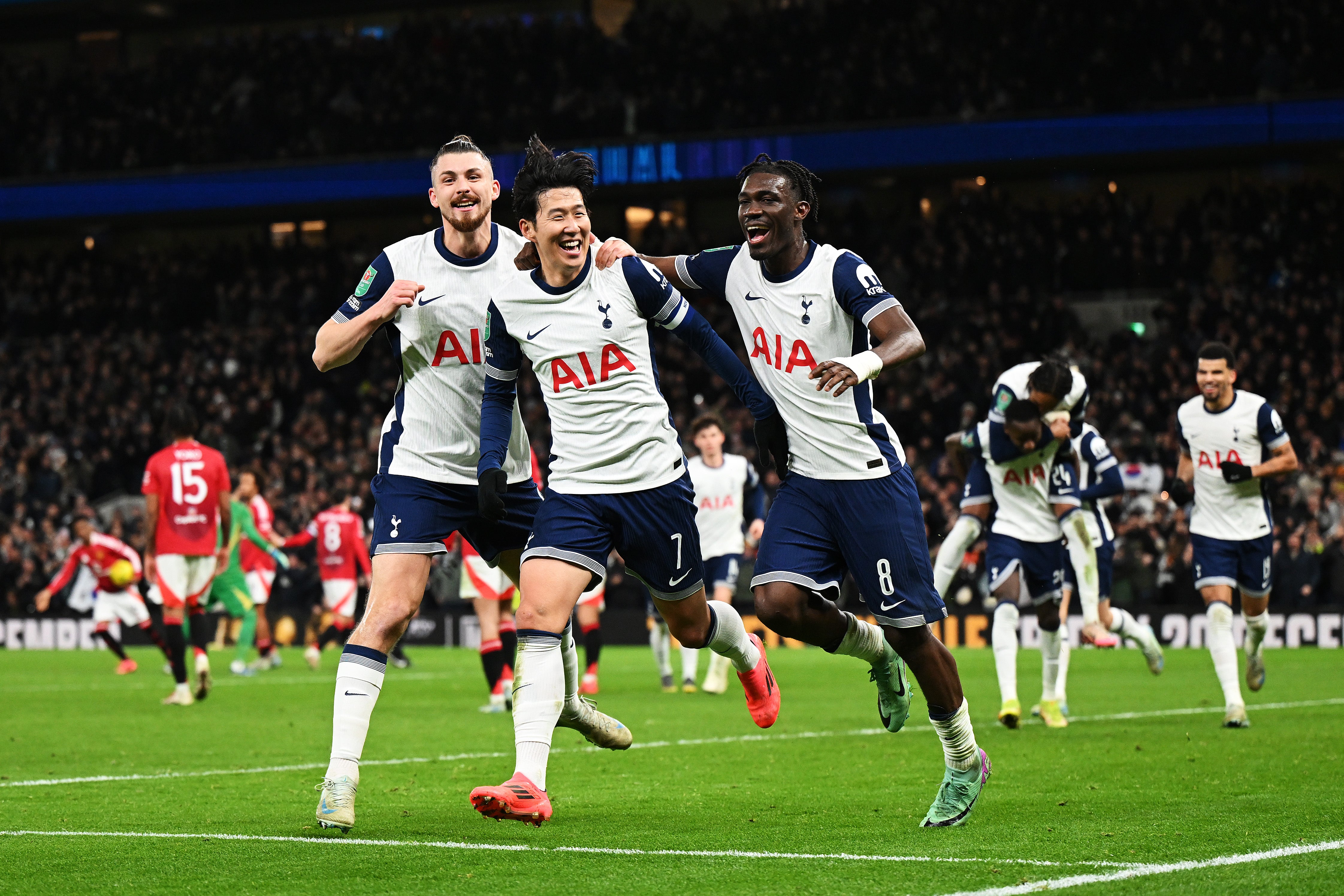 Son Heung-Min of Tottenham Hotspur celebrates with teammates Radu Dragusin and Yves Bissouma after scoring his team’s fourth goal