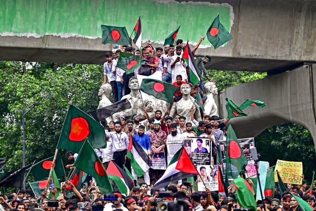 <p>Demonstrators wave Bangladesh's national flag during a rally in Dhaka celebrating the ousting of the country's former prime minister Sheikh Hasina</p>