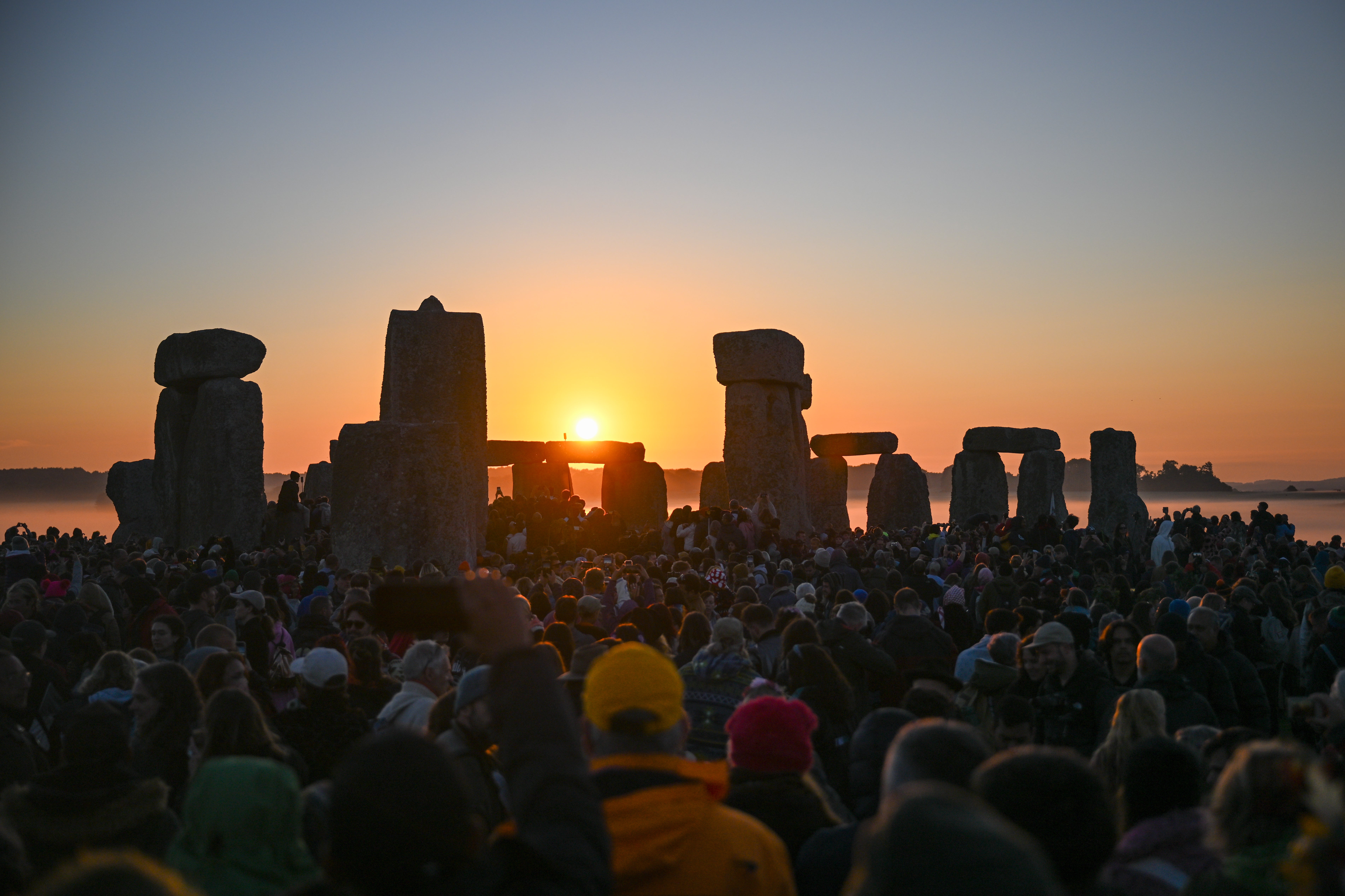 Visitors watch the sunrise at Stonehenge, on June 21, 2024 in Wiltshire, England