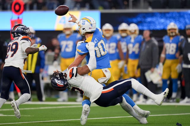 Los Angeles Chargers quarterback Justin Herbert is tackled as he throws by Denver Broncos linebacker Jonathon Cooper (Eric Thayer/AP)