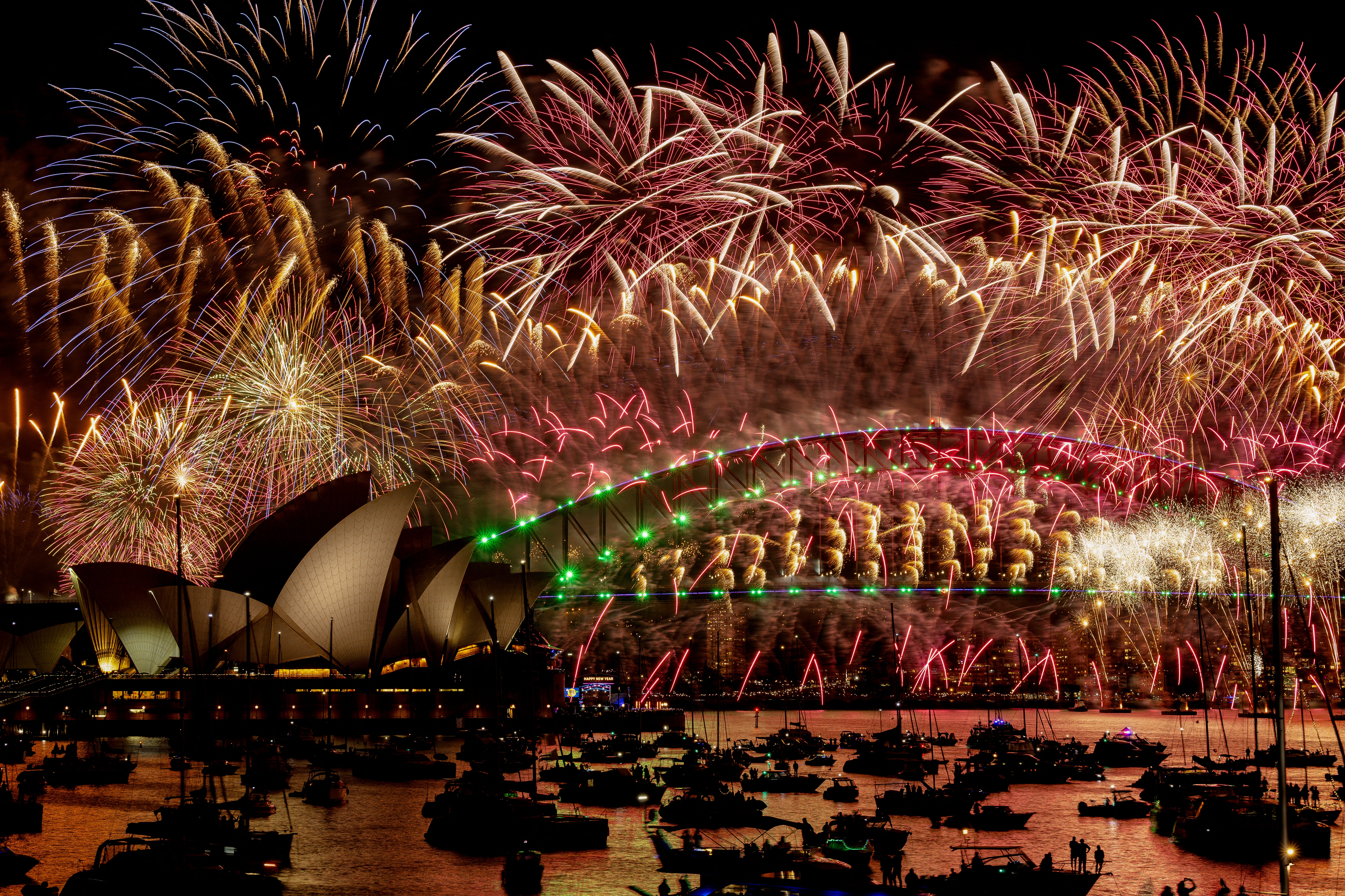 <p> Fireworks explode over the Sydney Harbour Bridge and Sydney Opera House (L) during New Year's Eve celebrations in Sydney on January 1, 2024</p>