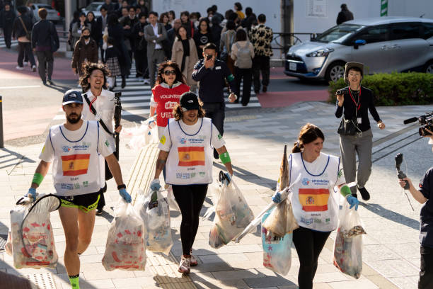 Mitglieder des spanischen Teams tragen während der Endphase der SPOGOMI-Weltmeisterschaft 2023 in Tokio Plastiktüten mit Müll