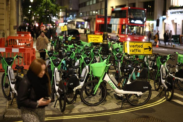 <p>Pedestrians negotiate their way around Lime e-bikes parked on the pavement and on the road in central London on November 7, 2023.</p>