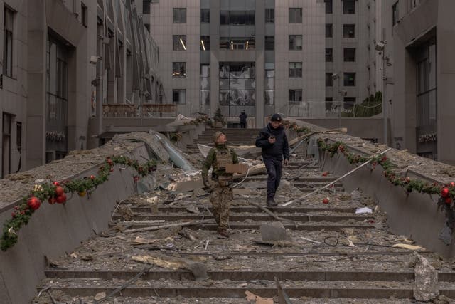 <p>Ukrainian law enforcement officers inspect damage to a building following a missile attack in Kyiv</p>