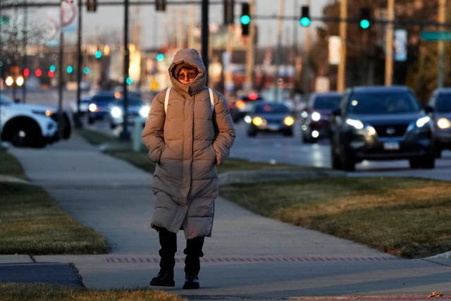 <p>A woman bundles up as she walks on the sidewalk in Wheeling, Illinois, during a cold weather snap. New research has found that the number of cold weather-related deaths has increased since the 1990s </p>