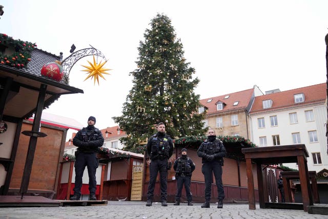 Policemen patrol a Christmas market, where a car drove into a crowd on Friday evening (Ebrahim Noorozi/AP)