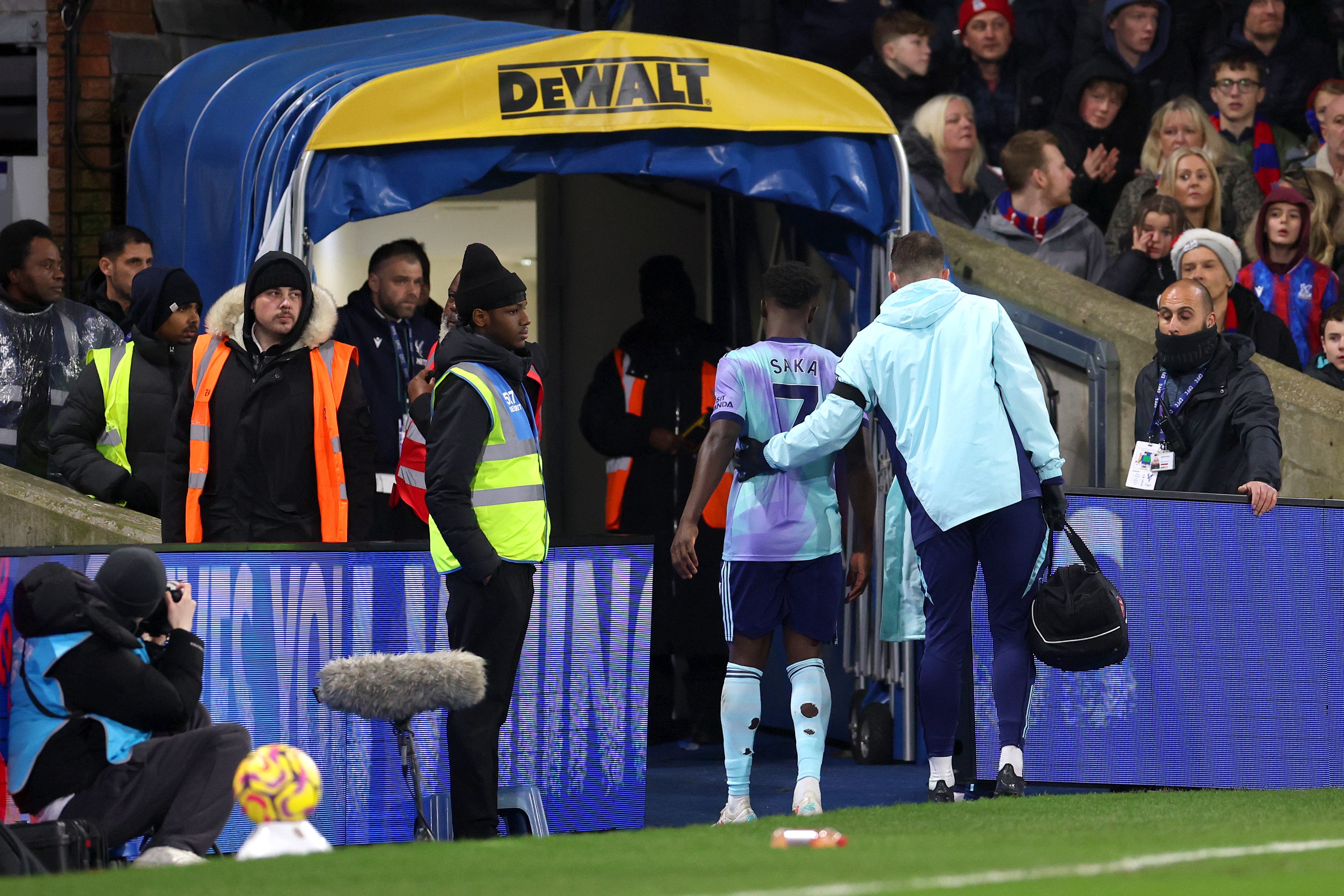 Bukayo Saka of Arsenal is assisted as he walks down the tunnel