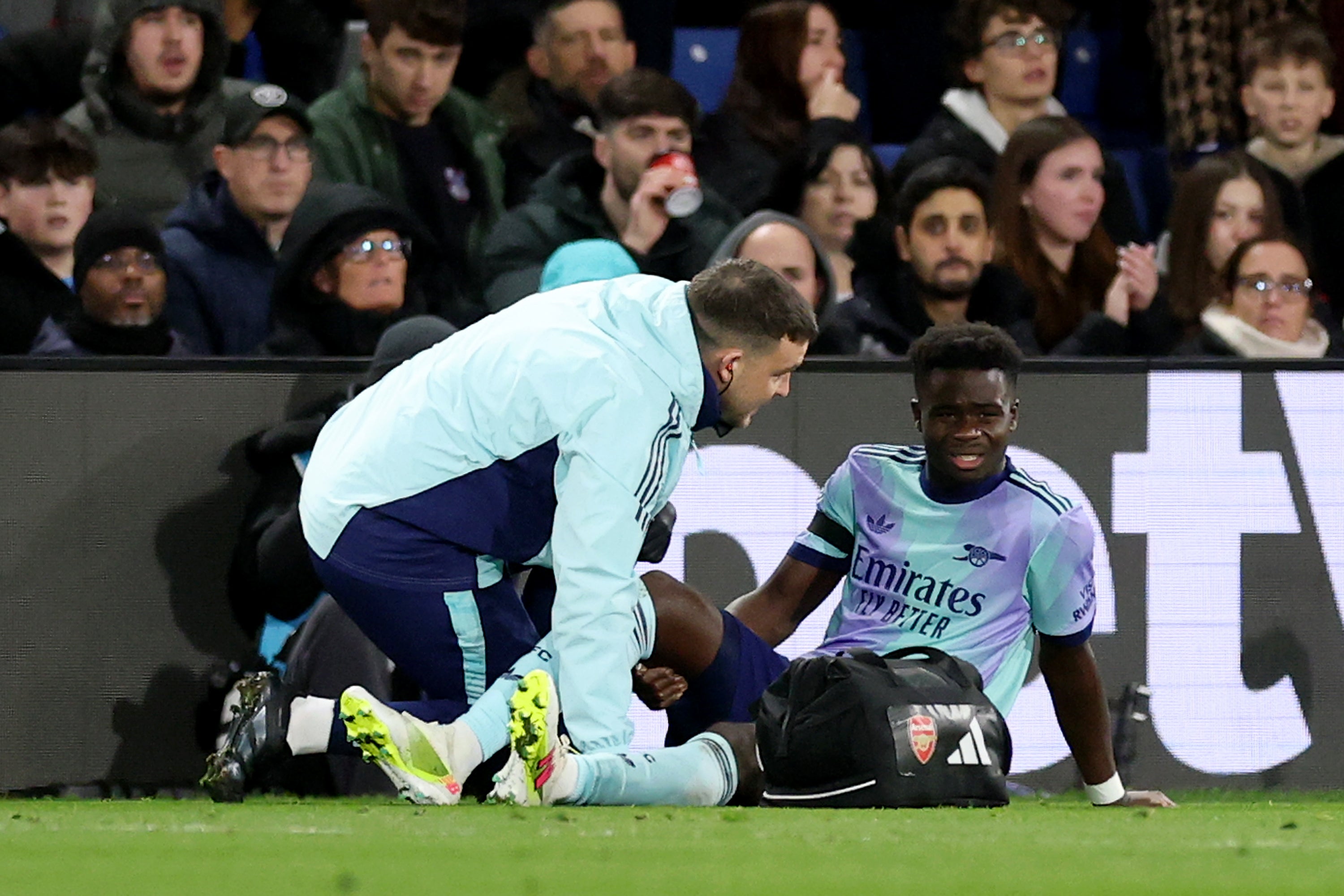 Bukayo Saka of Arsenal receives medical treatment