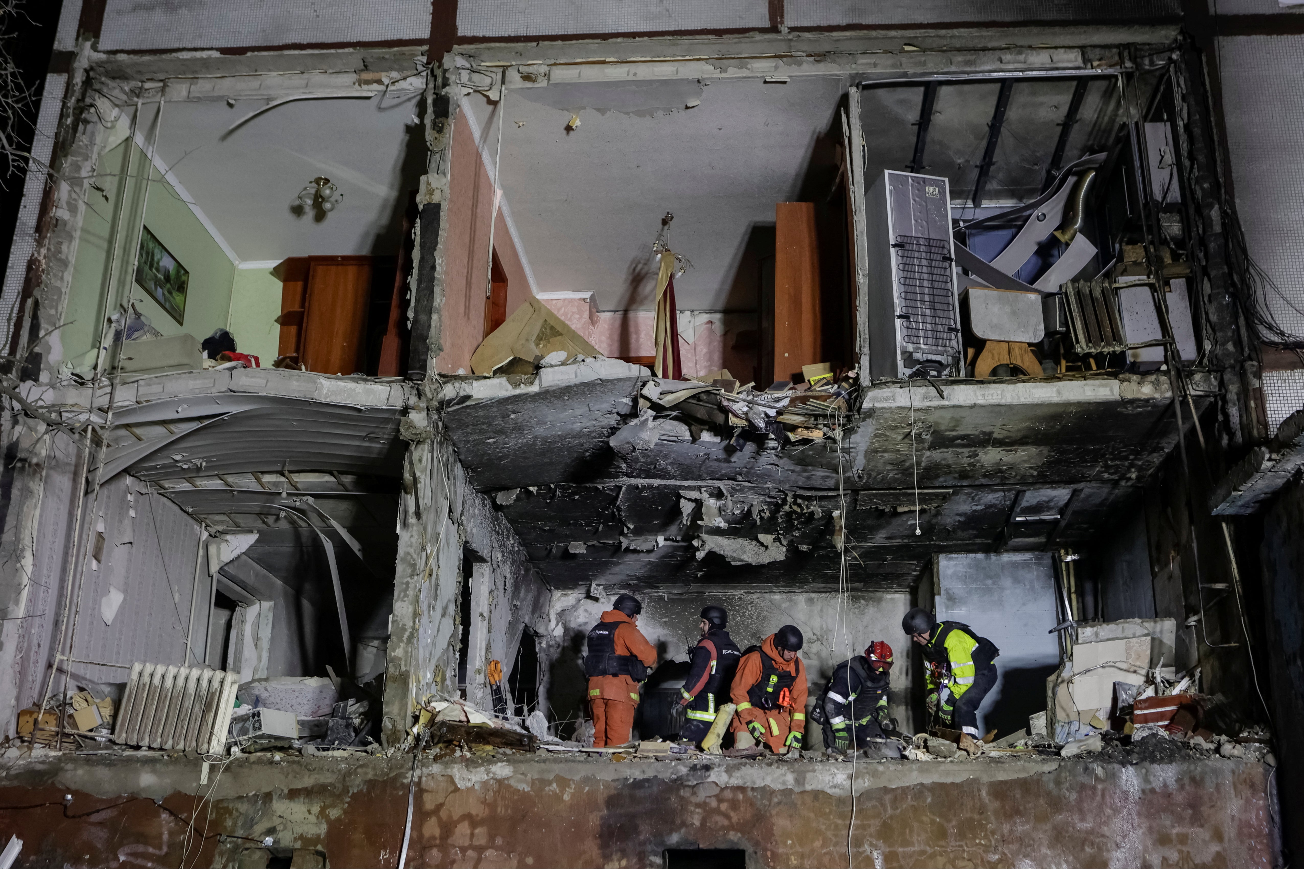 Rescuers work at a site of an apartment building damaged by Russian drone strike in Kharkiv