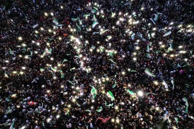 <p>People gather at Aleppo’s Saadallah al-Jabri Square to celebrate the fall of Syria’s ousted dictator Bashar al-Assad</p>