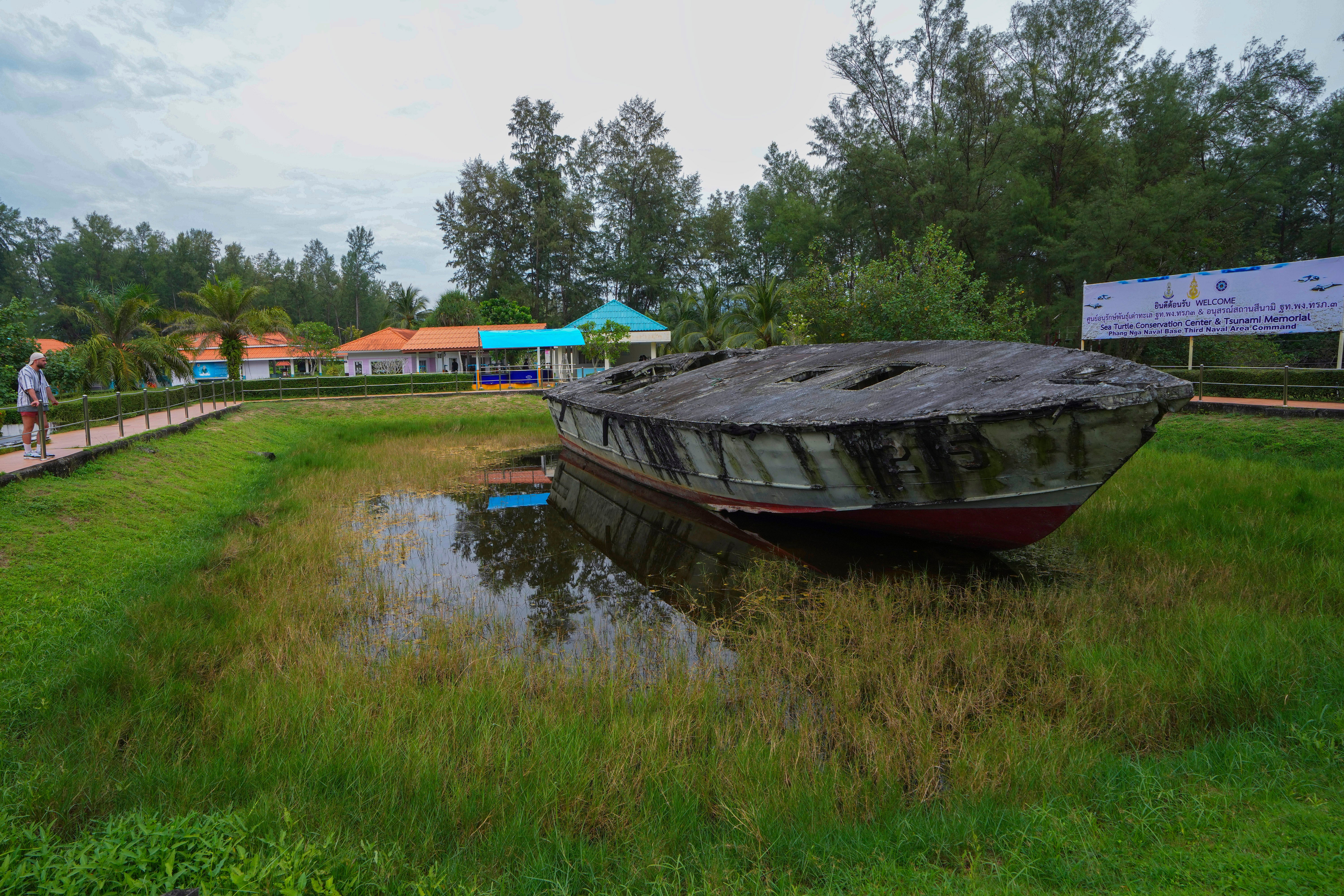 A visitor looks at coastal reconnaissance boat T215 at Tsunami memorial in Phang Nga Naval Base province