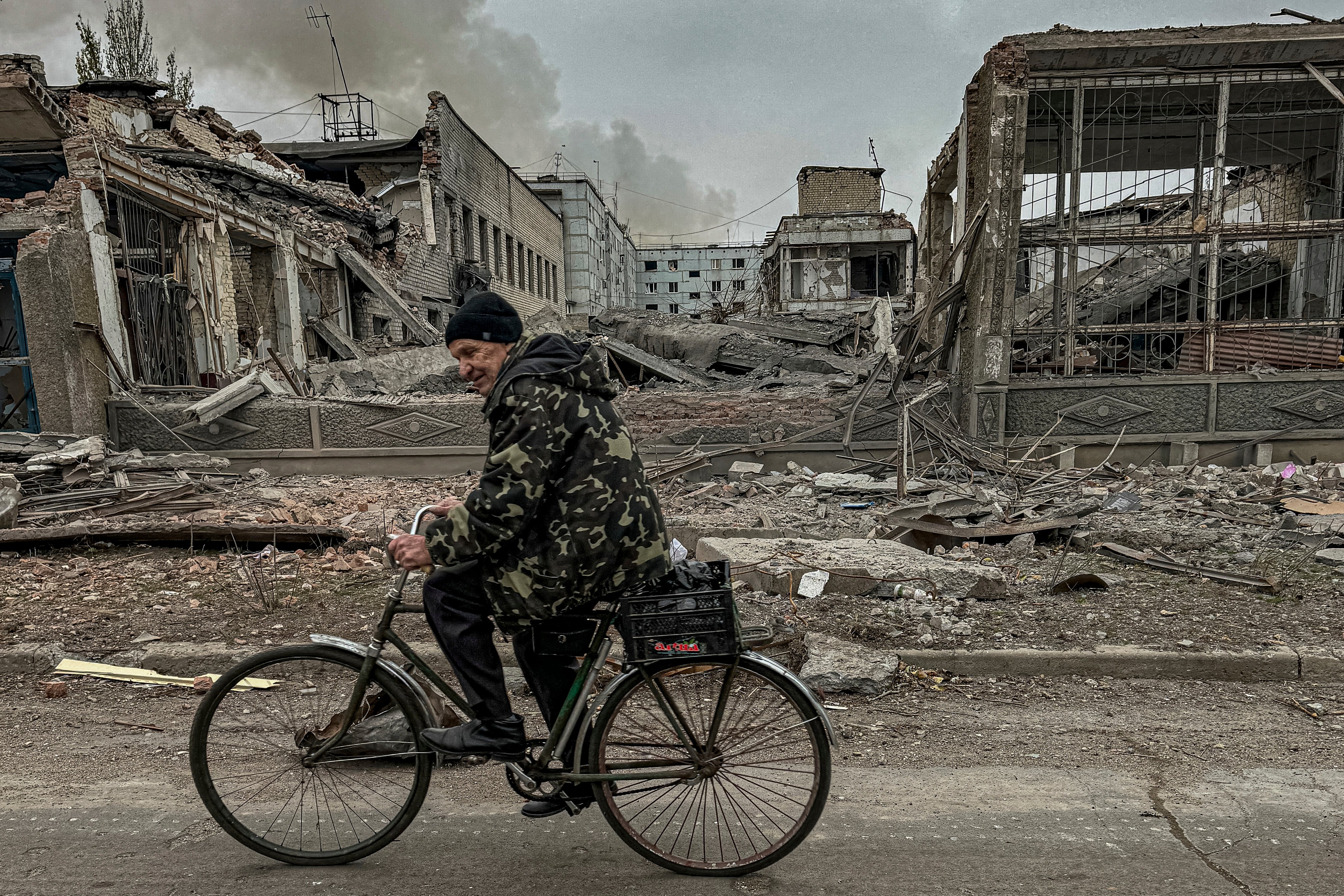 File: A man rides on a bike in front of the mail office which was destroyed by a Russian airstrike in Kurakhove, Donetsk region