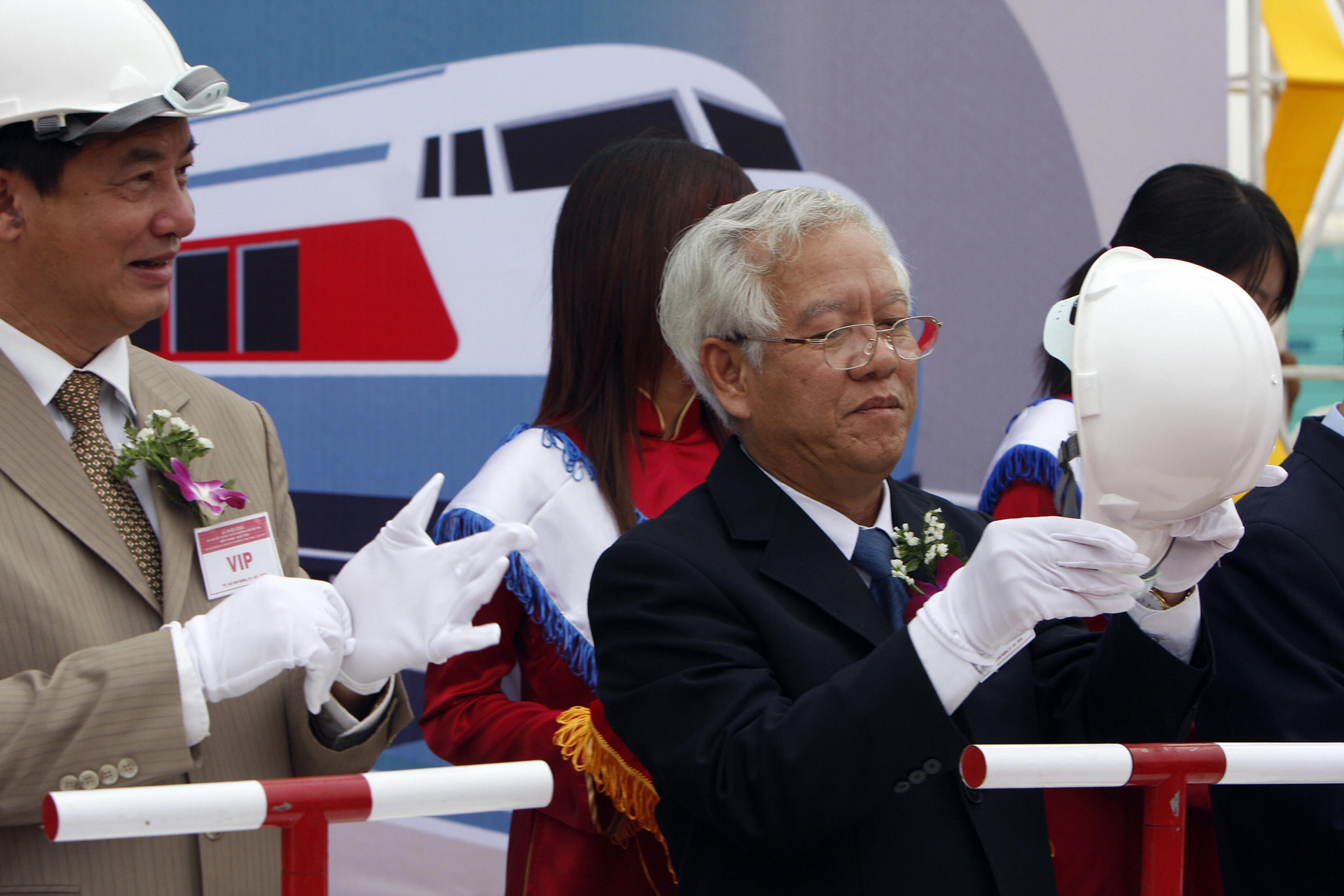 Vietnamese Minister of Transport Ho Nghia Dung (L) and Ho Chi Minh city mayor Le Hoang Quan put on gloves and helmets as they attend the ground-breaking ceremony of the one-billion-dollar first metro line in Ho Chi Minh City on 21 February 2008