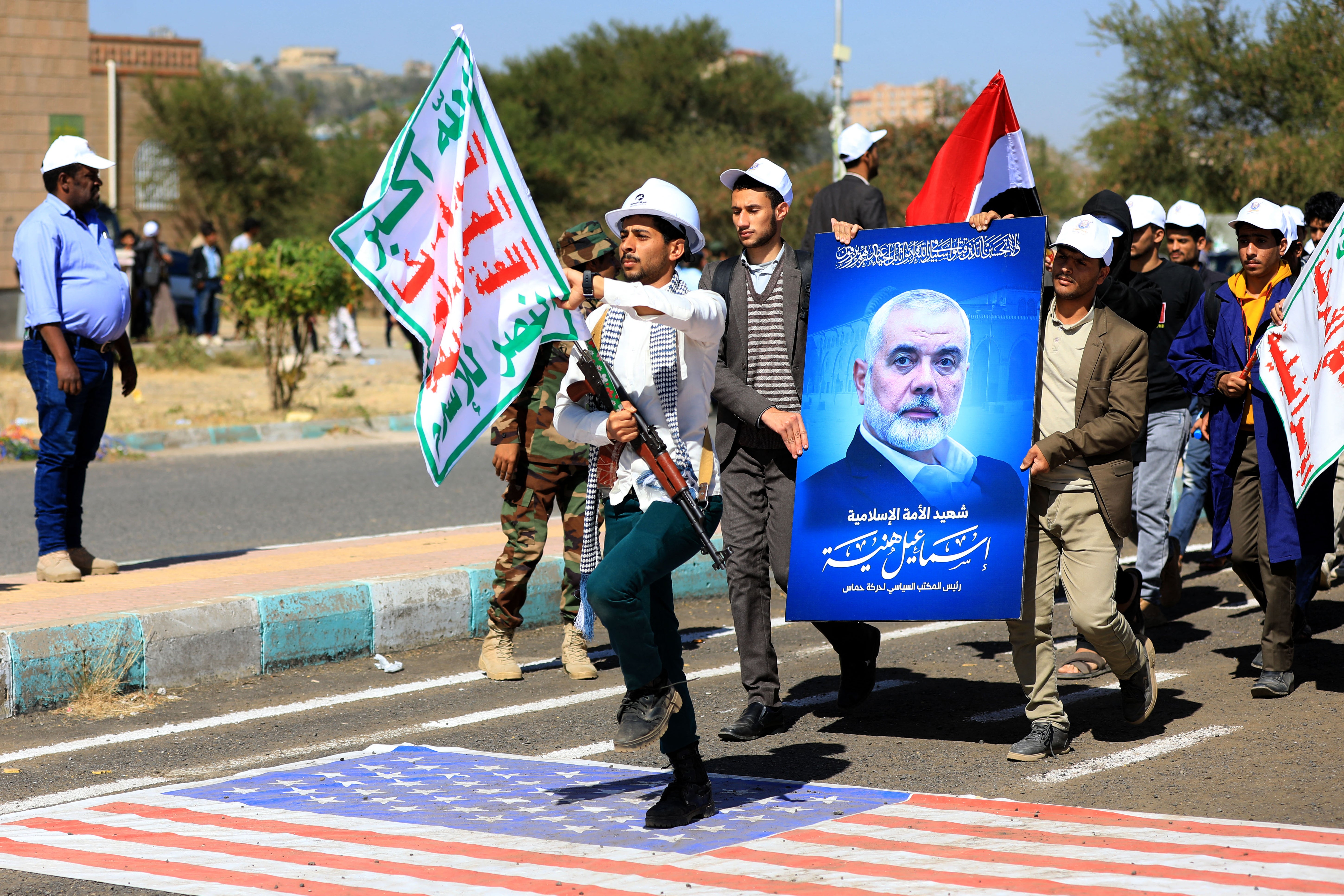 <p>University students carry the portrait of slain Hamas political leader Ismail Haniyeh during a parade</p>