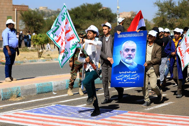 <p>University students carry the portrait of slain Hamas political leader Ismail Haniyeh during a parade</p>